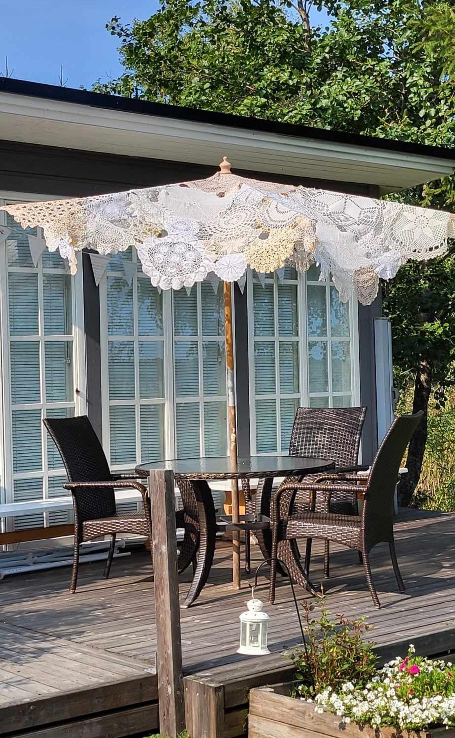 The doily umbrella made by Soile crowns the cottage terrace. Photo Soile Björklund