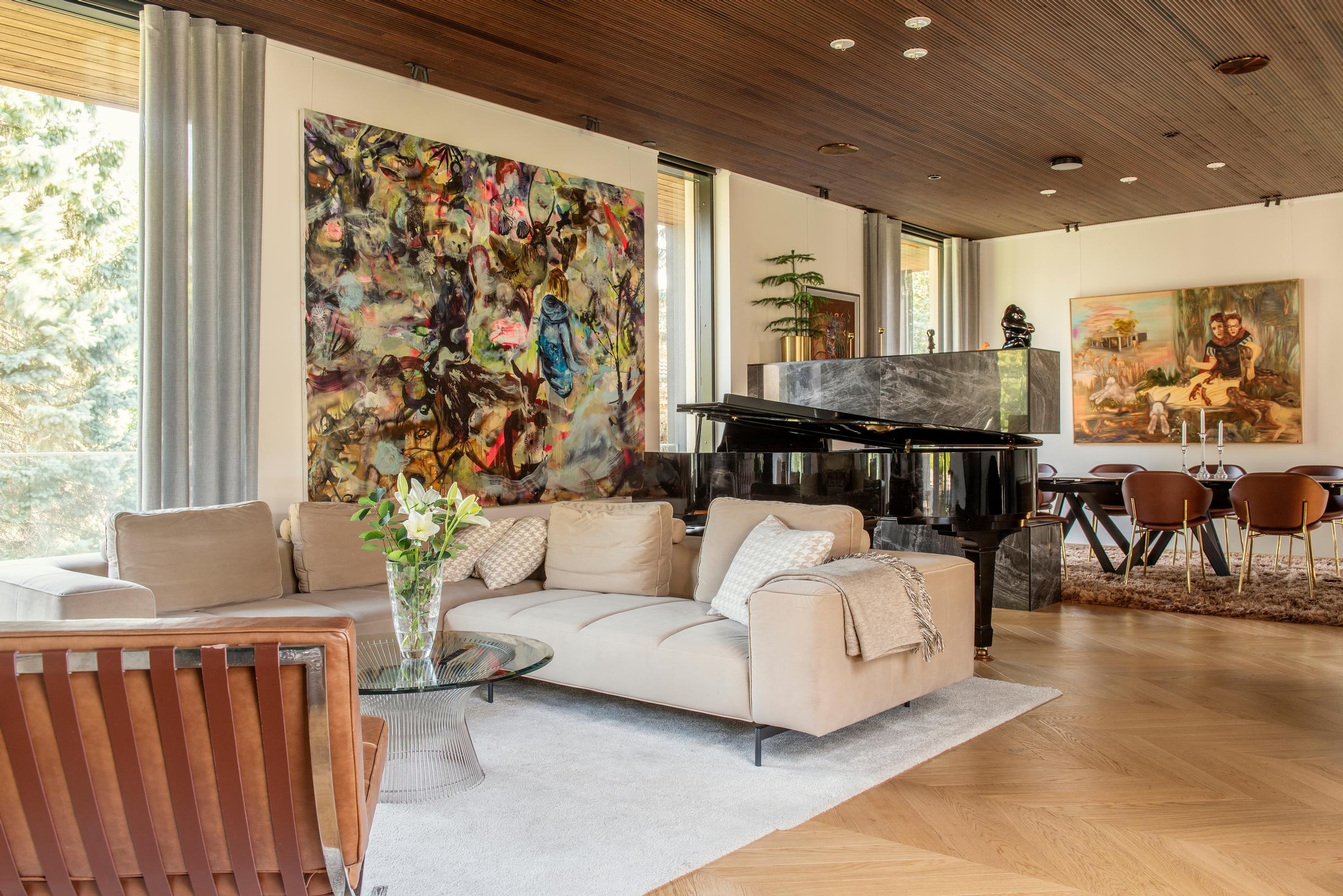 In the living area, a large painting and a light-colored sofa