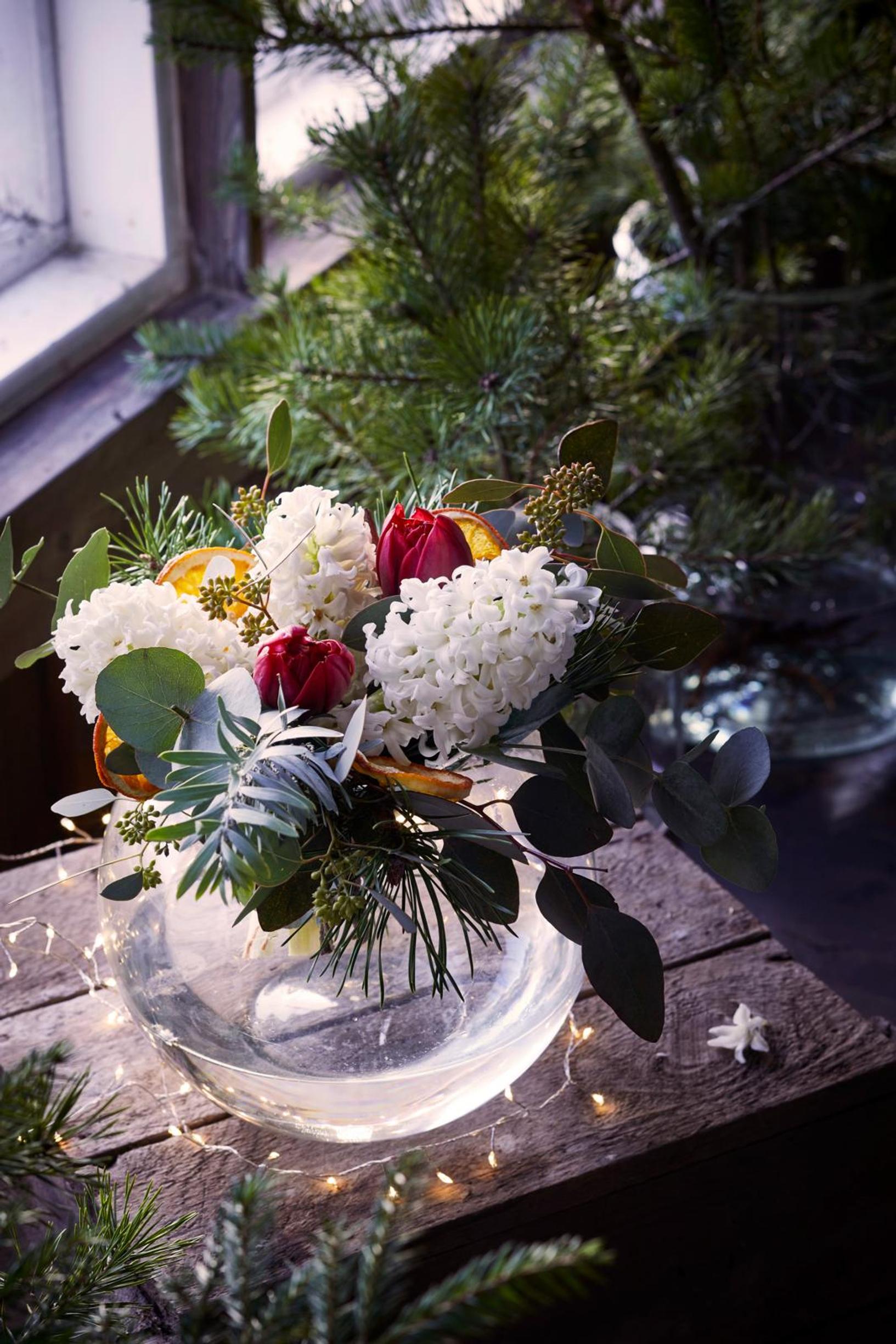 A bouquet of hyacinths and various eucalyptus branches, accented with dried orange slices.