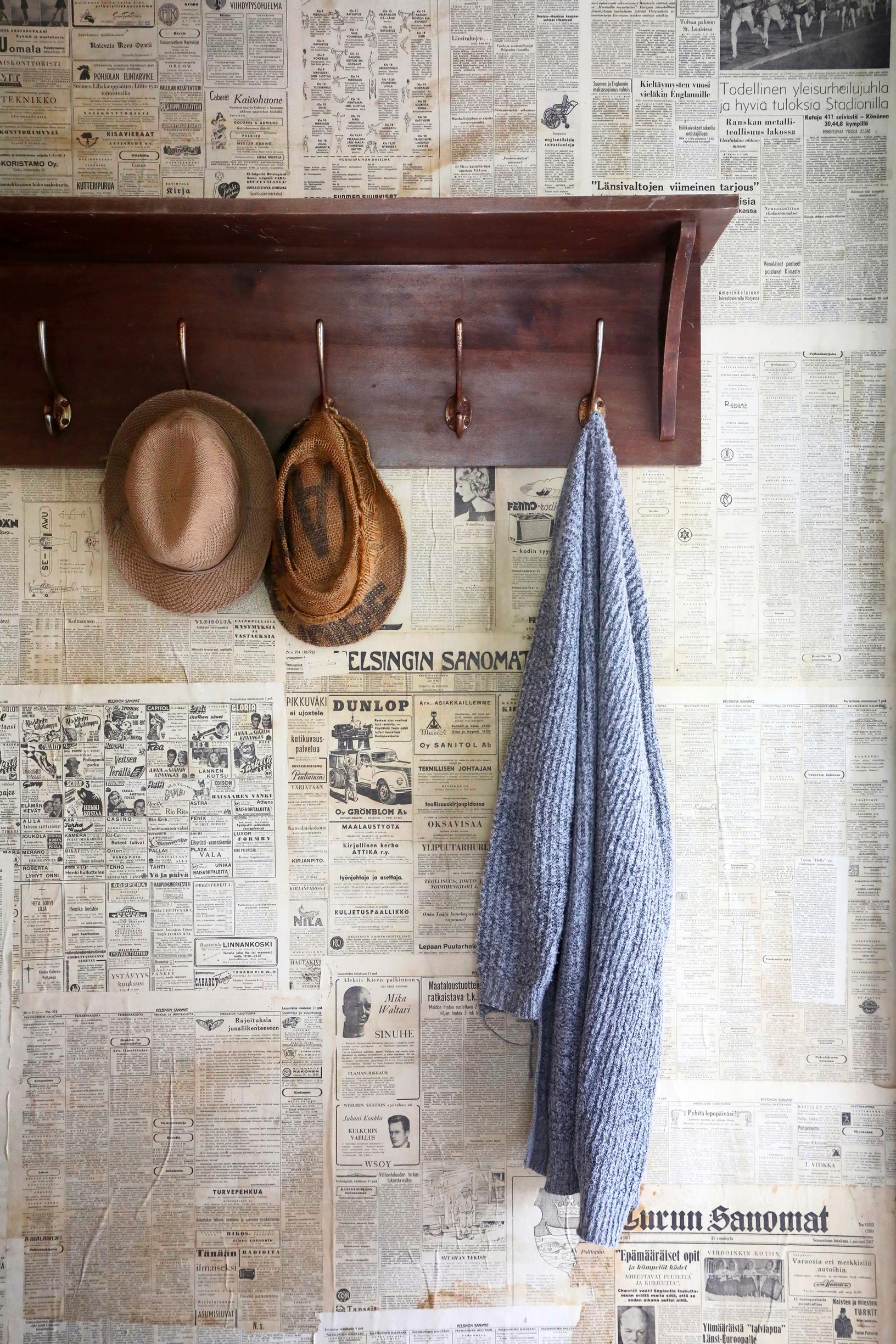 A wallpapered wall with an old coat rack.