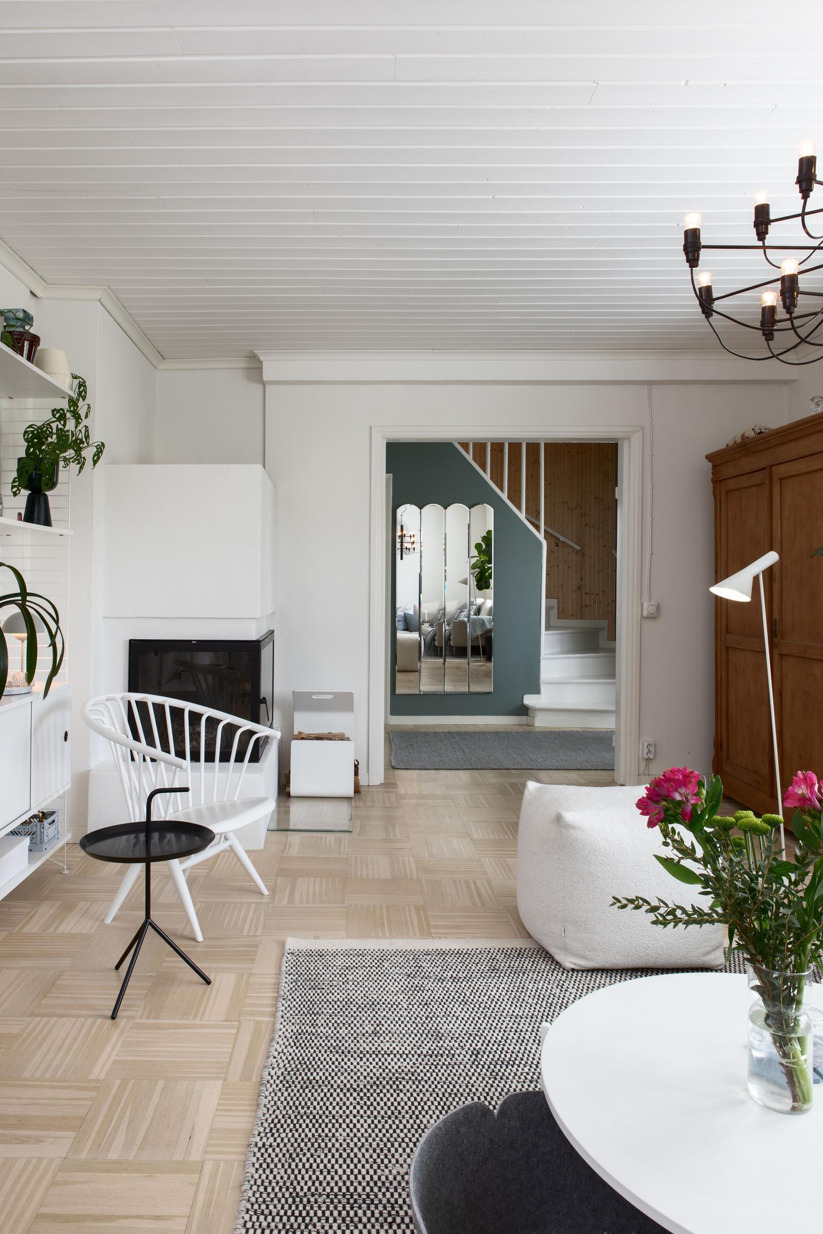 Living room, with an open fireplace in the corner and a large doorway.