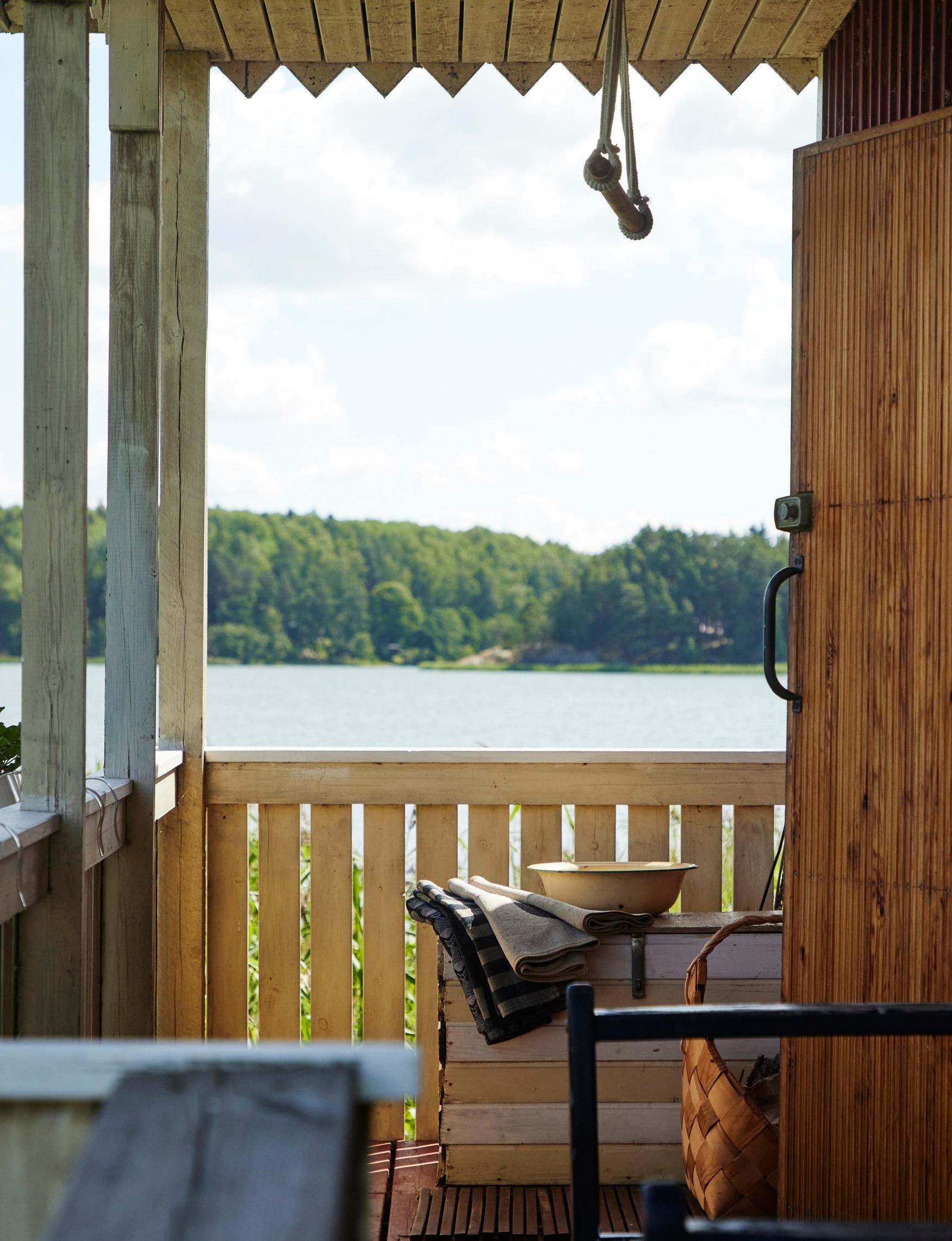 an enamel wash‑basin and towels on the veranda with a view to the sea and the opposite shore