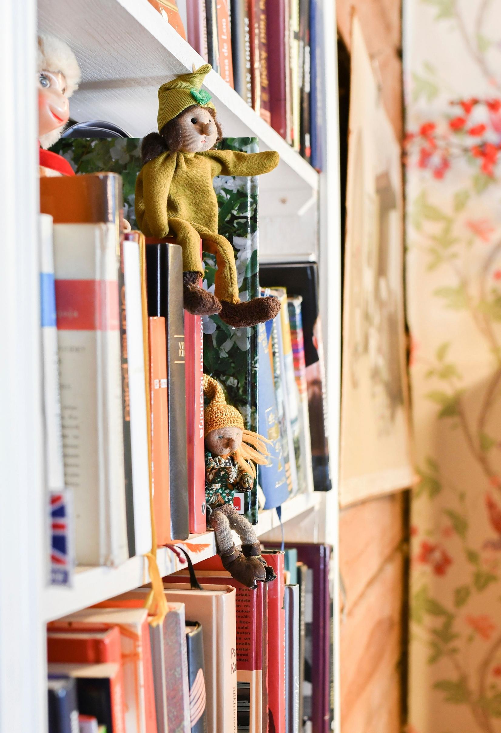Adorable gnomes peeking out from the bookshelf.