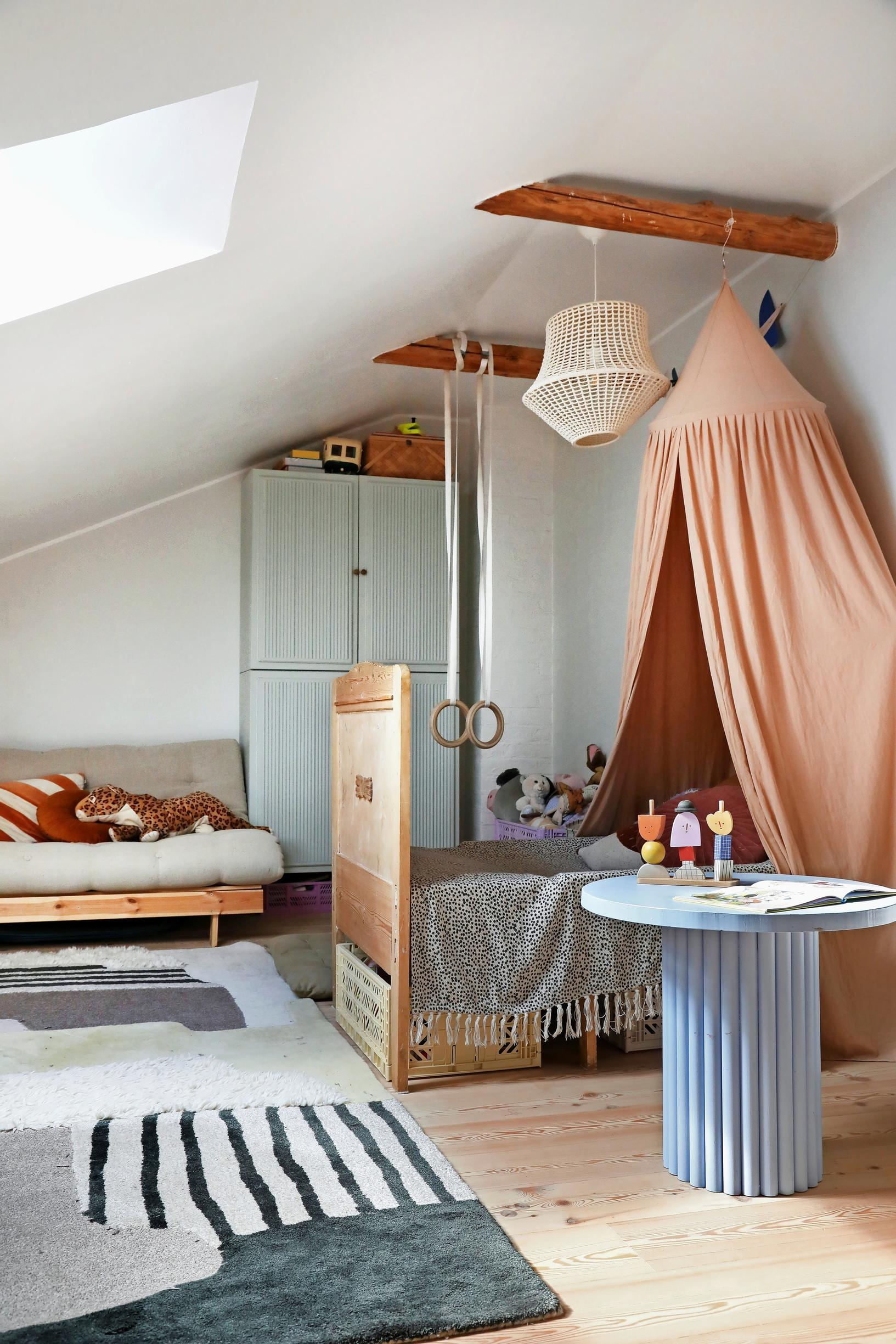 children’s room with a canopy bed and a Karup futon sofa