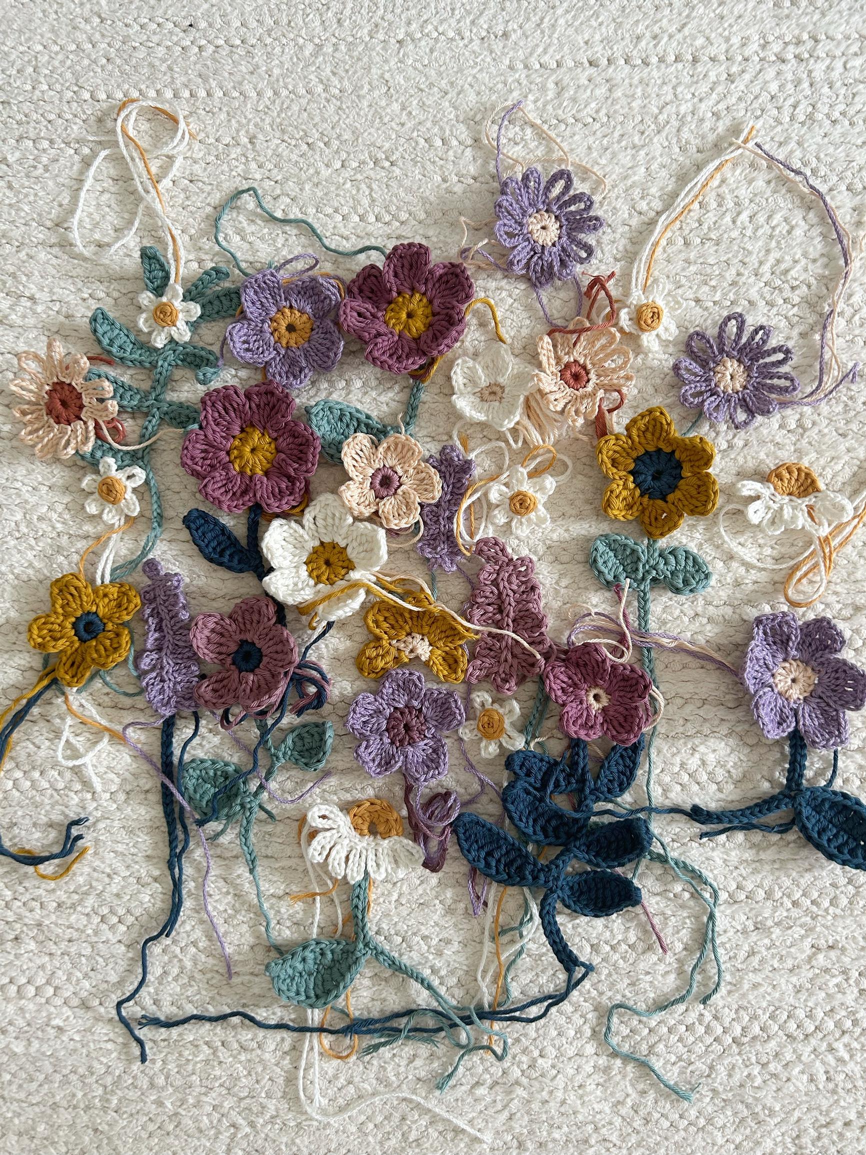 Crocheted flowers waiting to be arranged into a painting.