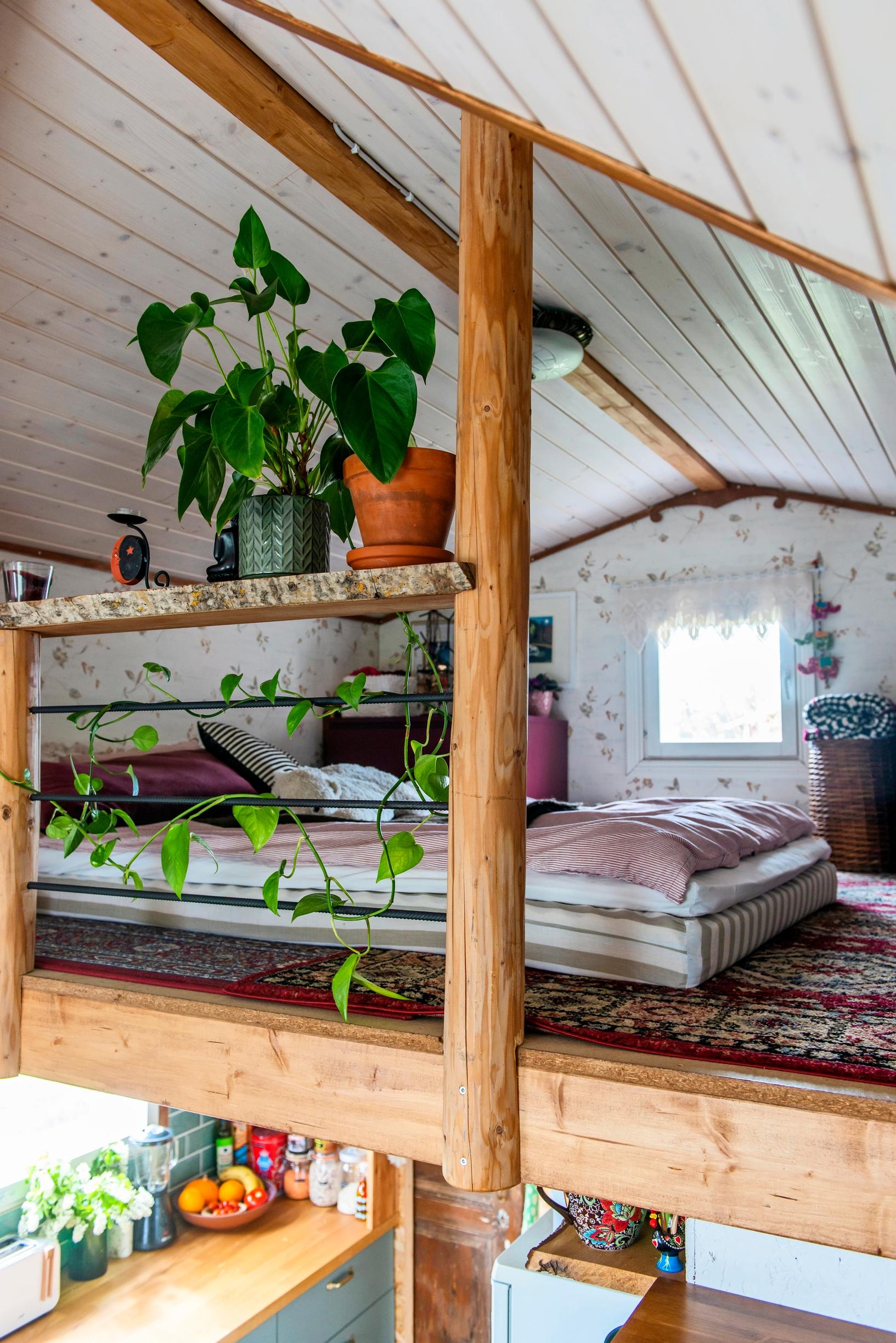 View of the loft with a thick mattress and houseplants