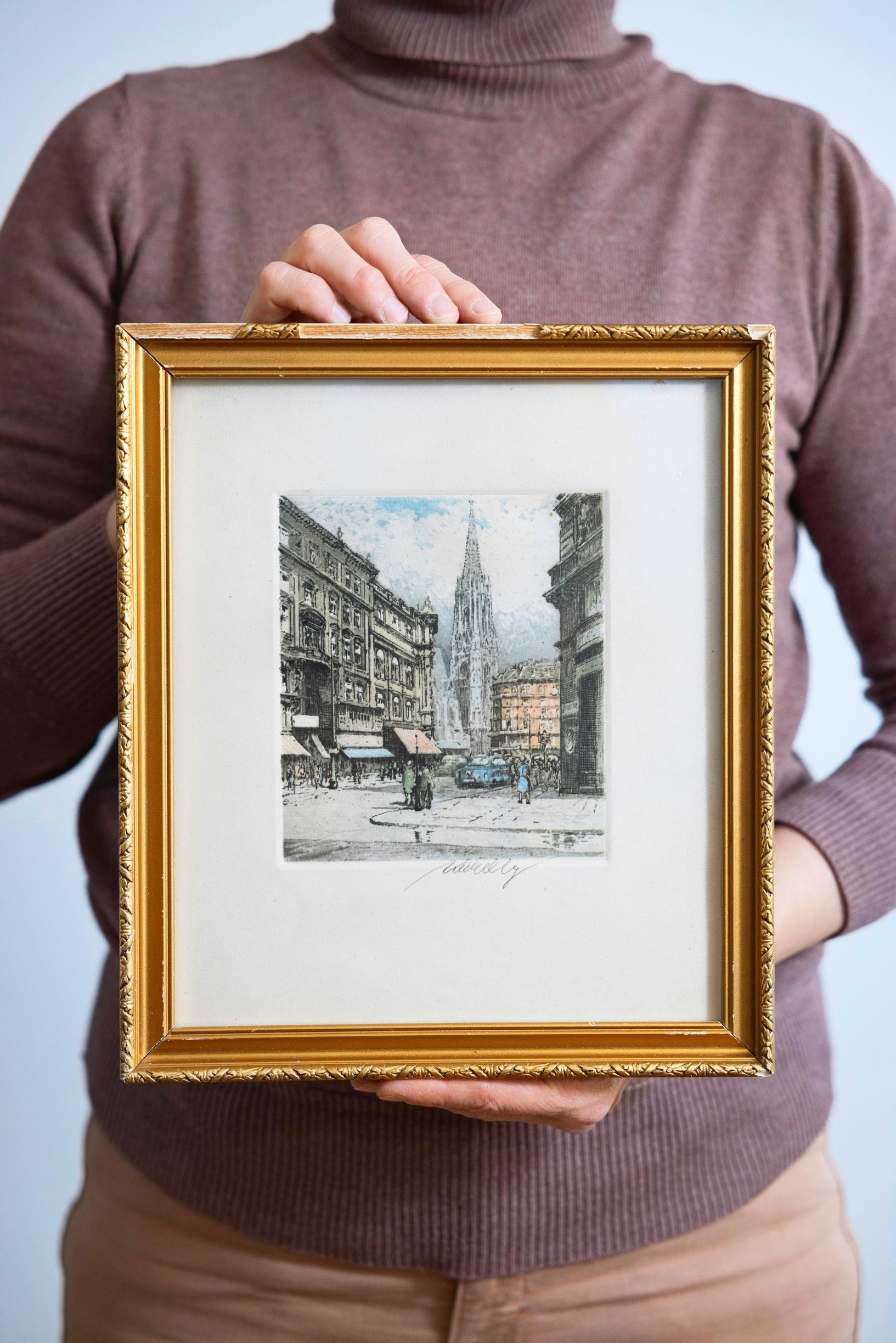 a woman holding a painting in her hands