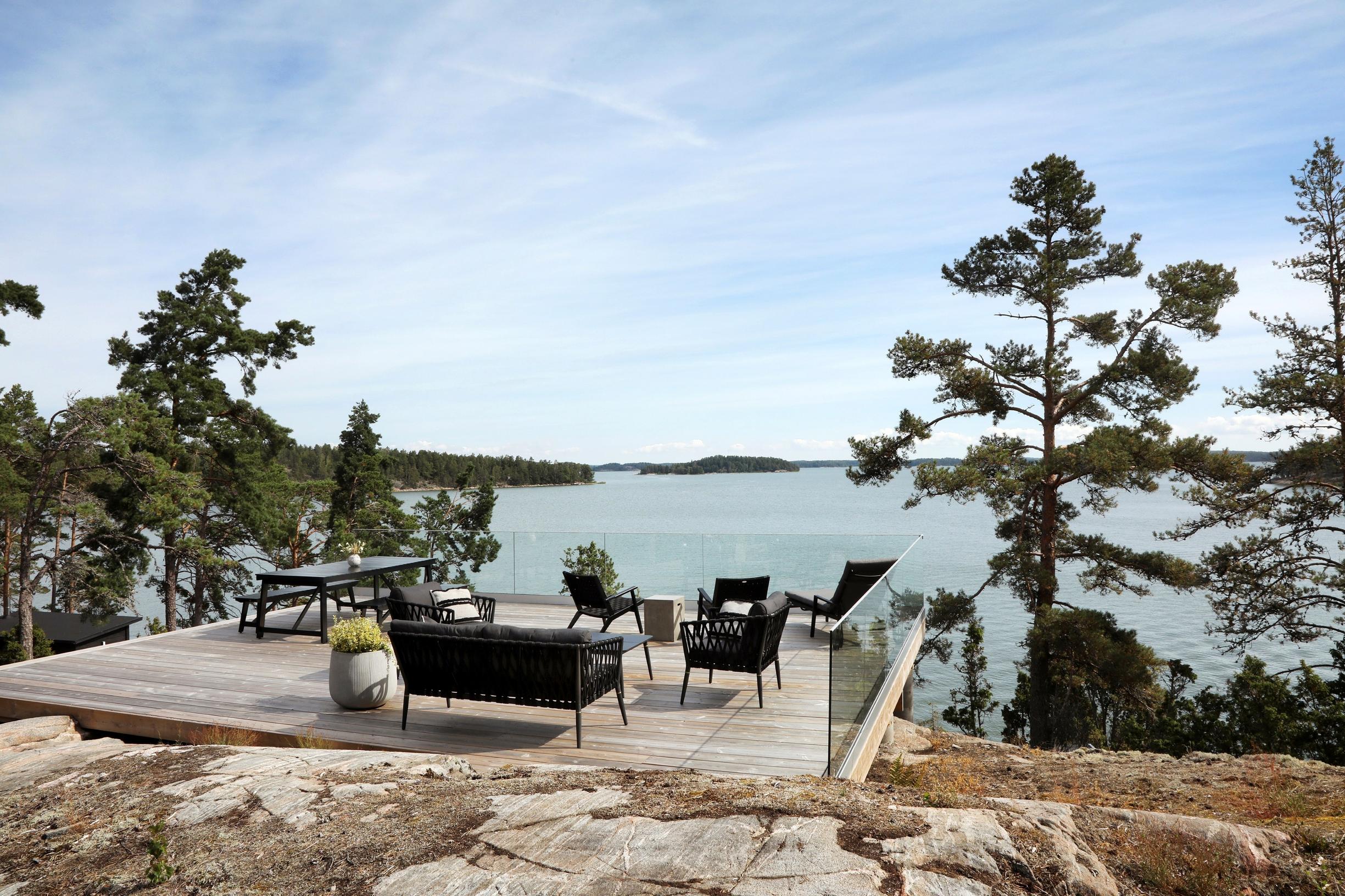 A terrace with a sea view enclosed by glass railings
