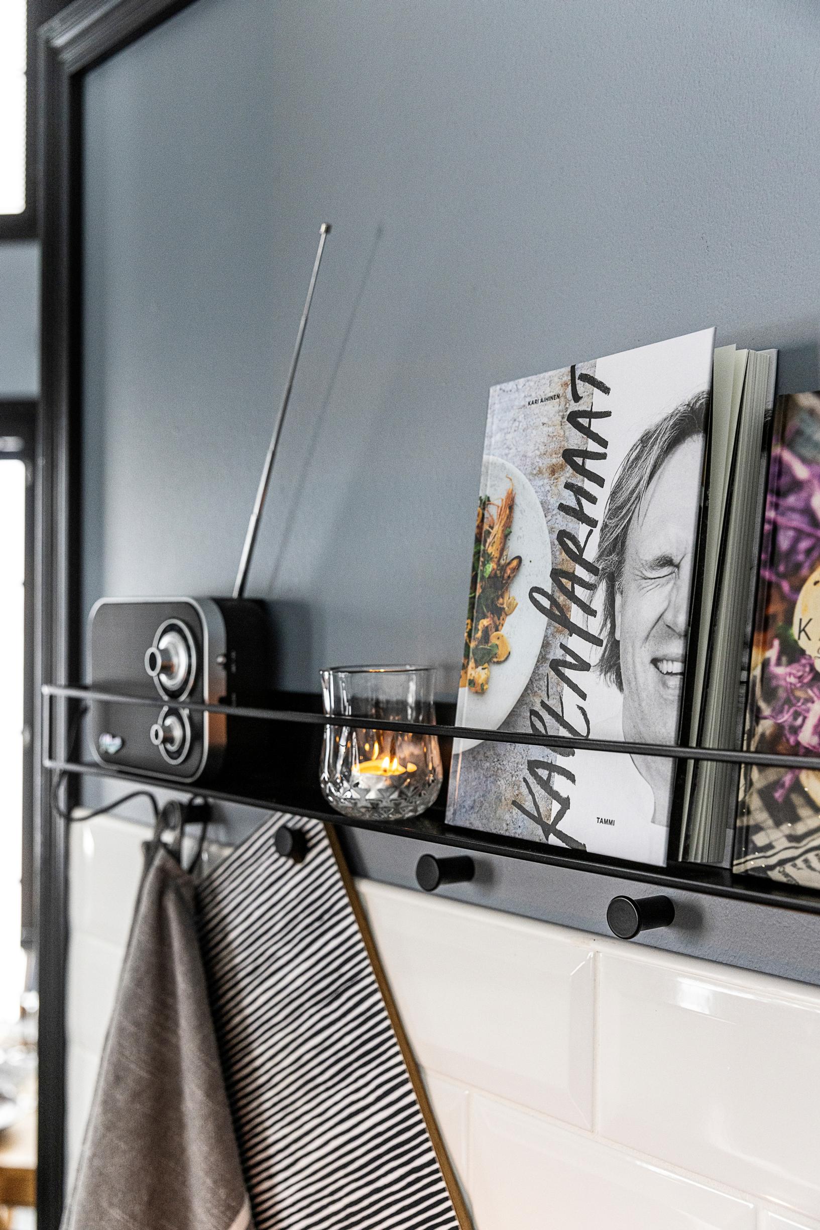 A kitchen rack with chef Kape Aihinen’s cookbook and a travel radio.