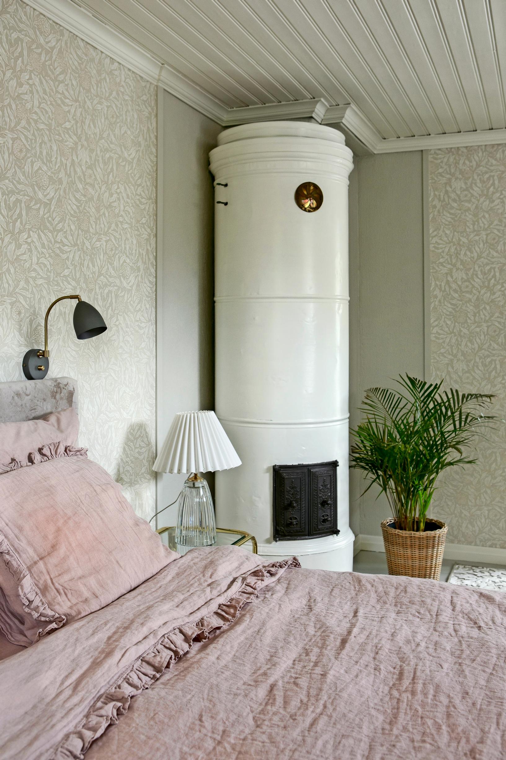 a barrel stove in the corner of a bedroom