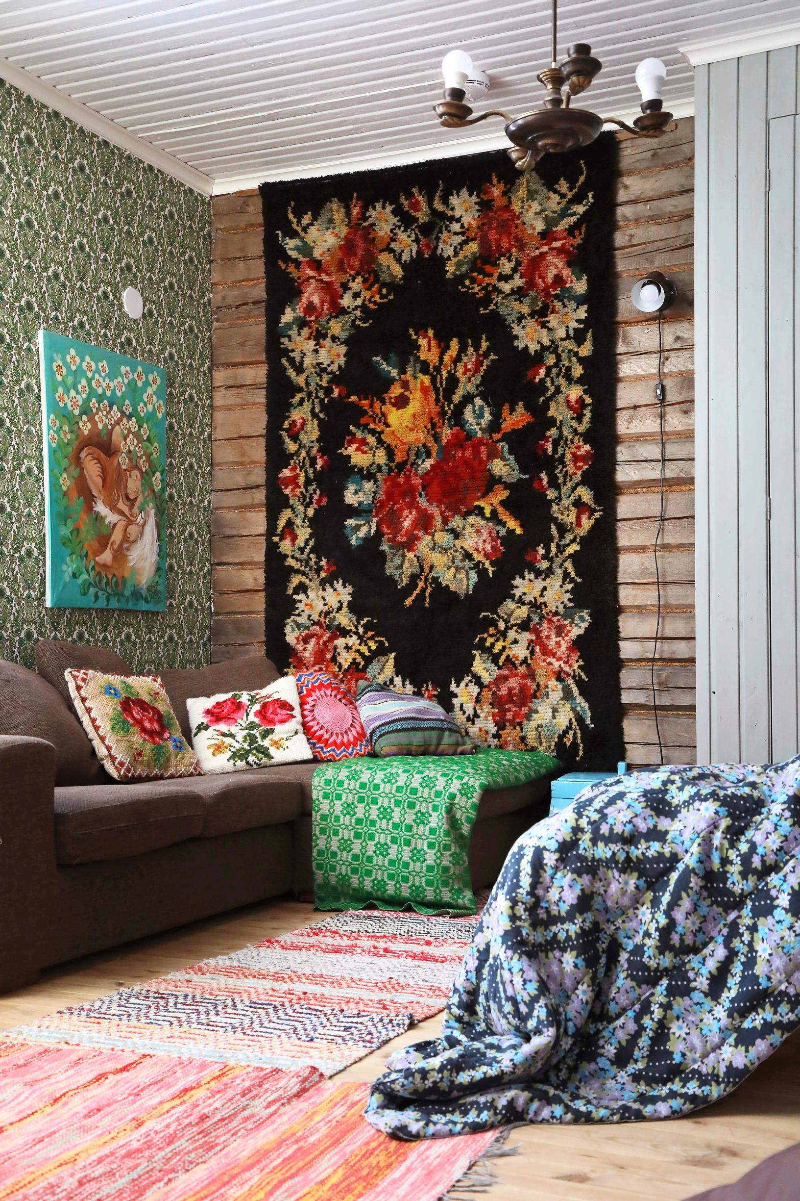 The living room’s rose-patterned rya rug and a log wall that once stood exposed to the weather.