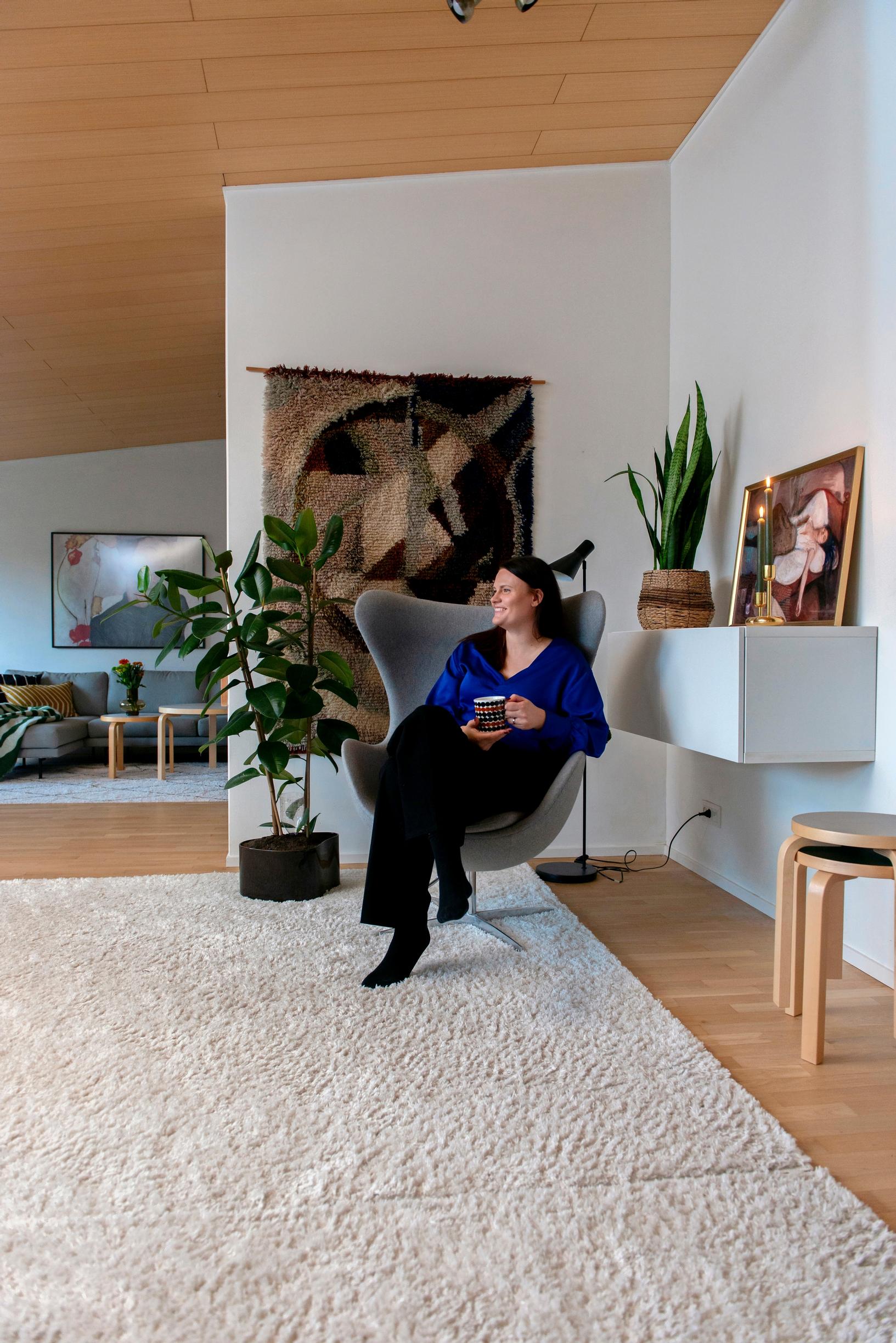 Image of a spacious living room with a large light-colored rug and design furniture.