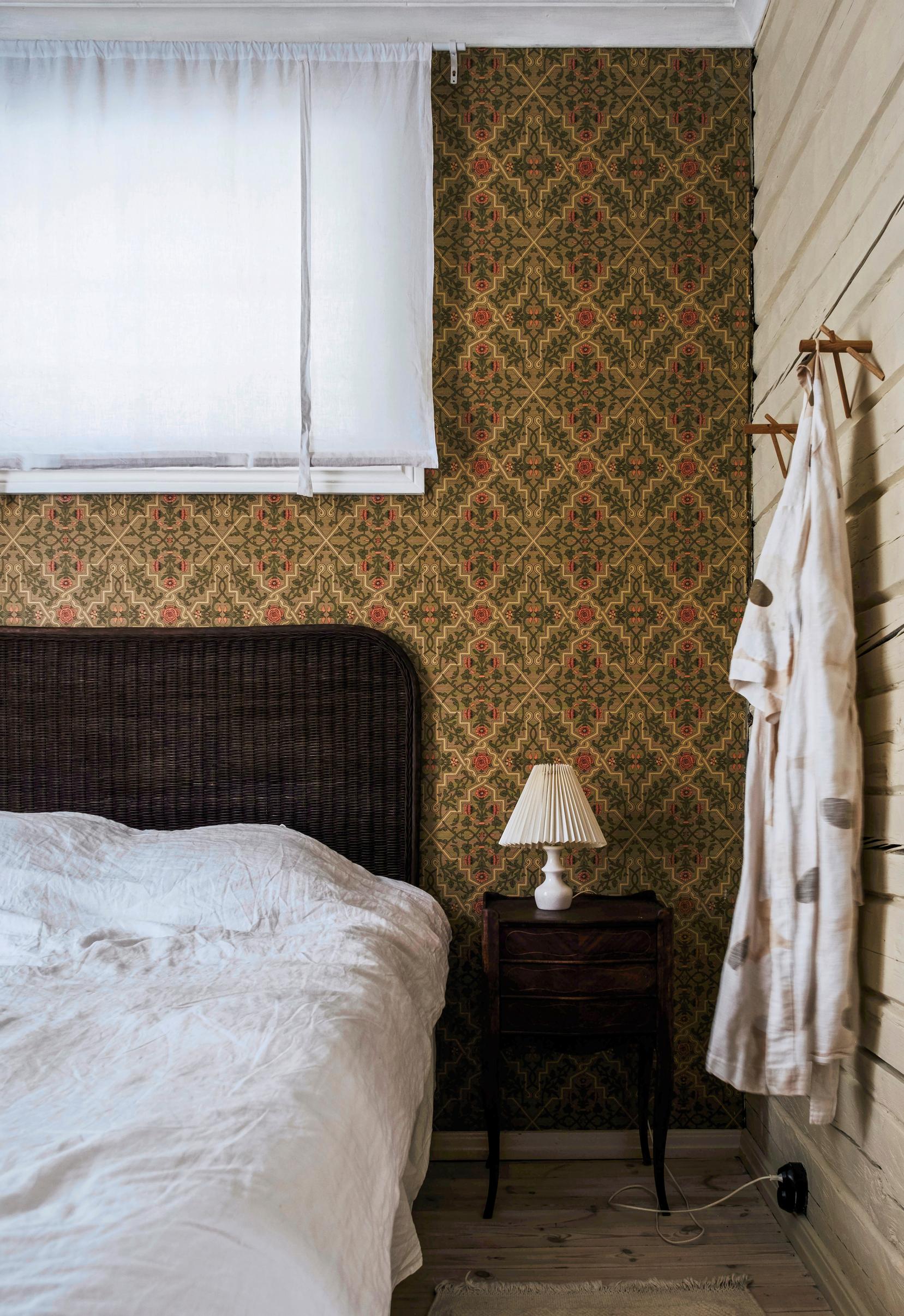 A bed and the dark wallpaper on the background wall.