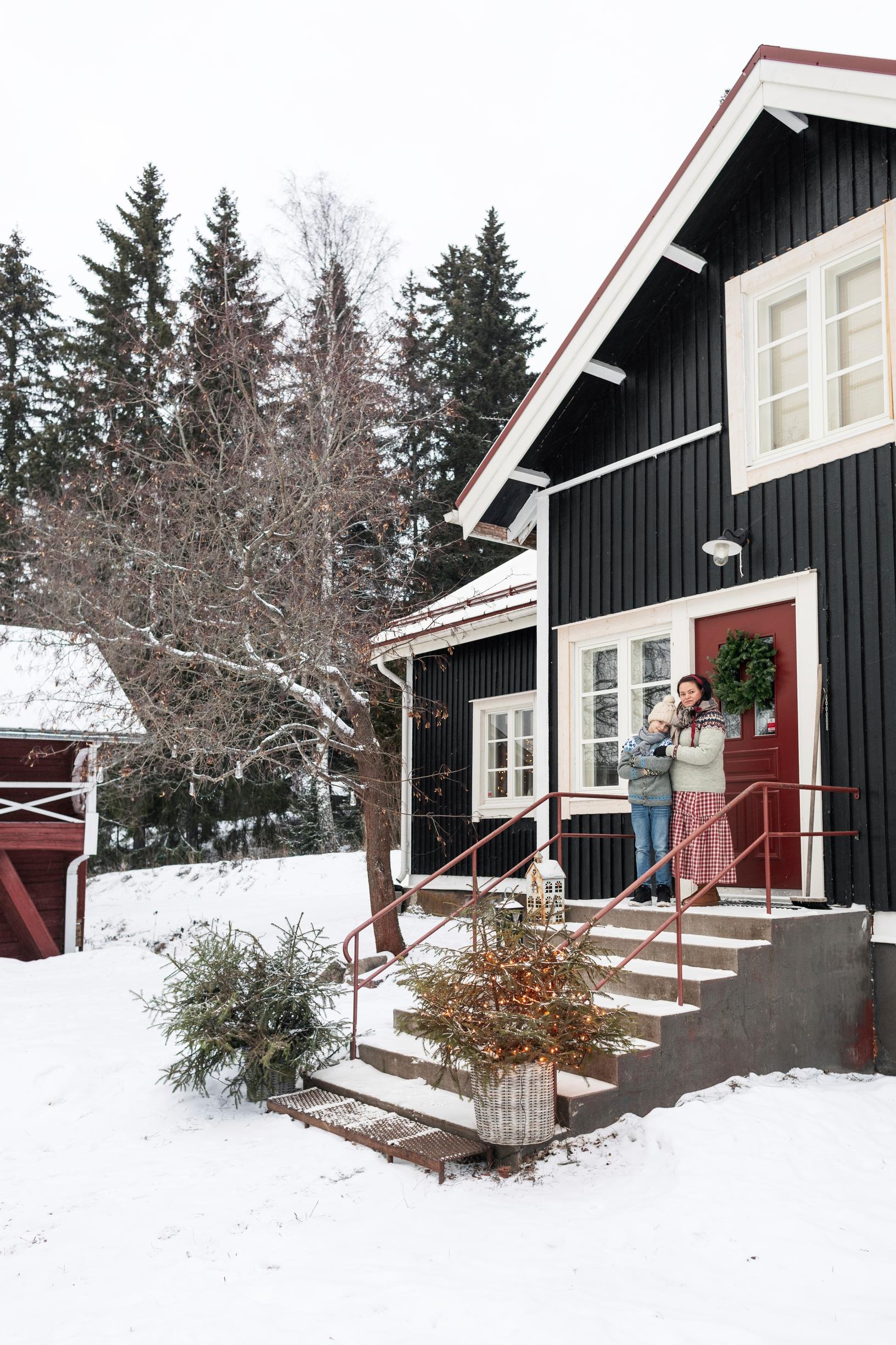 The black farmhouse in a snowy landscape.