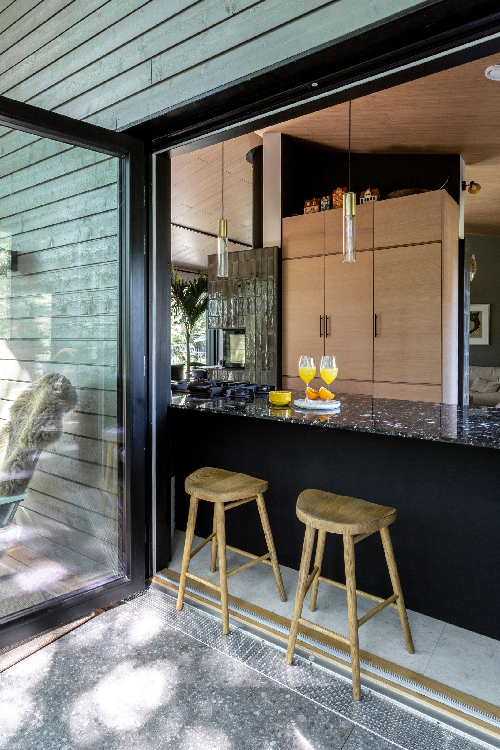 Windowed doors open onto the terrace with bar stools next to the counter.