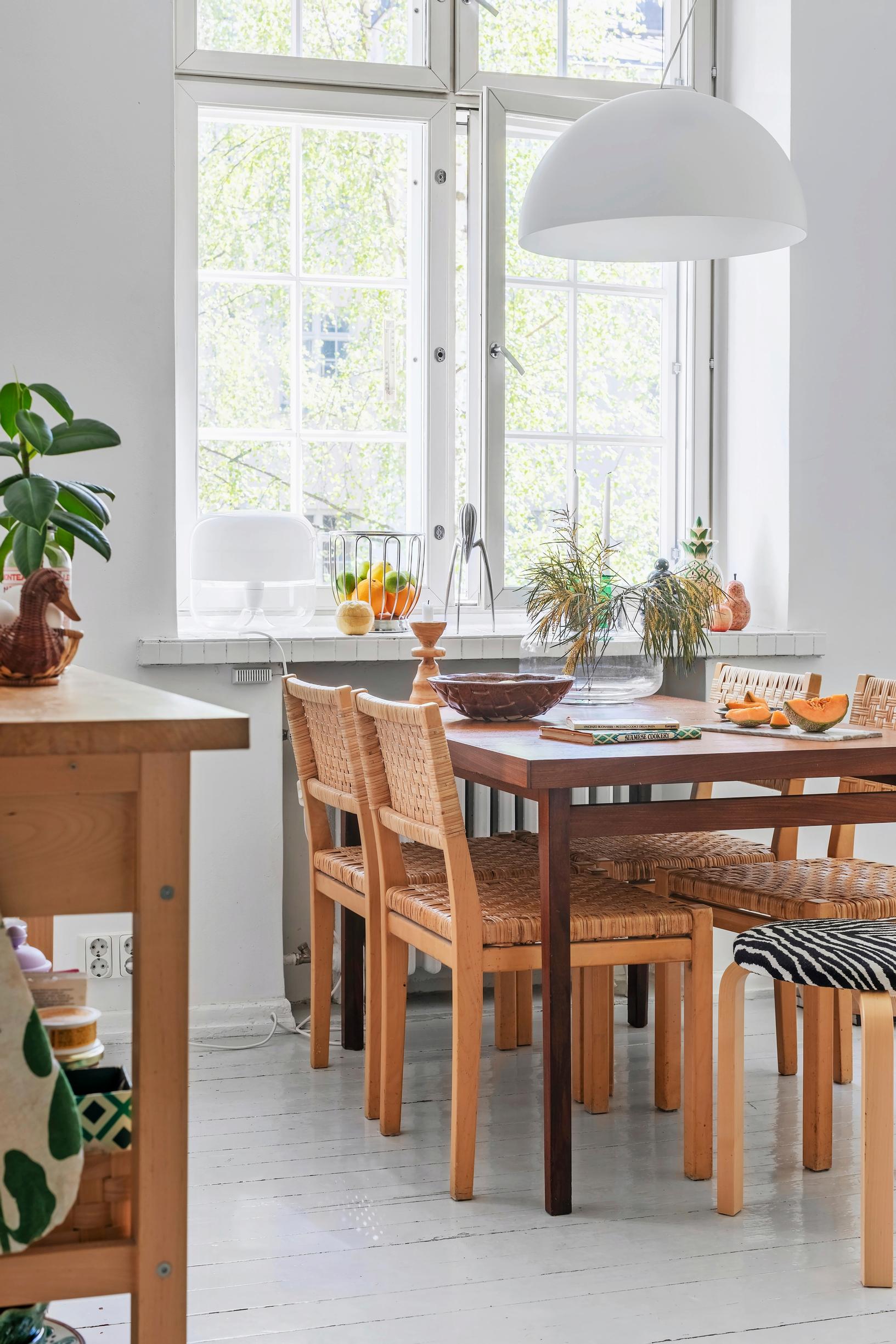 Rattan chairs designed by Aino Aalto around a teak dining table