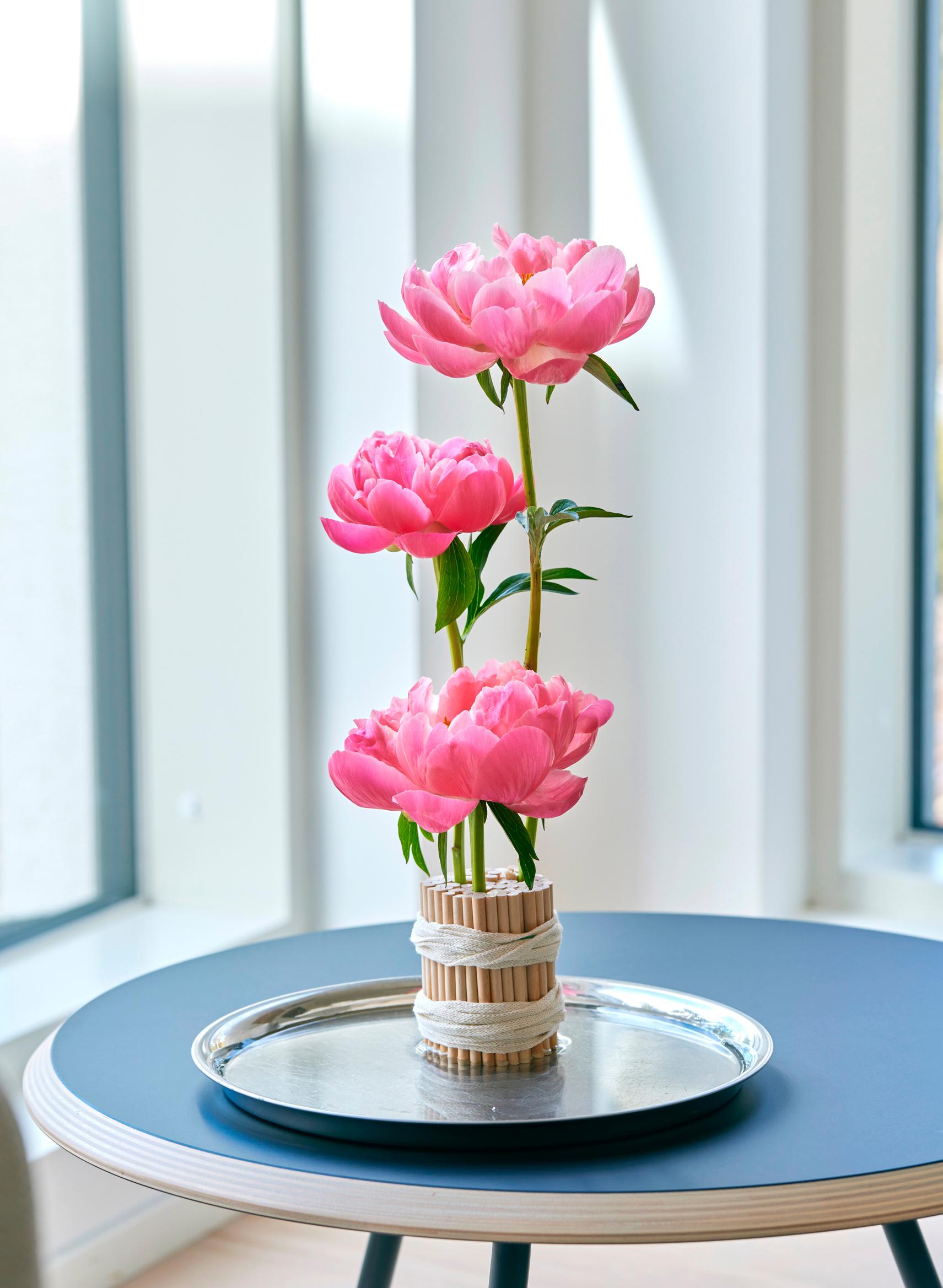 Peony flower arrangement in a slatted base.