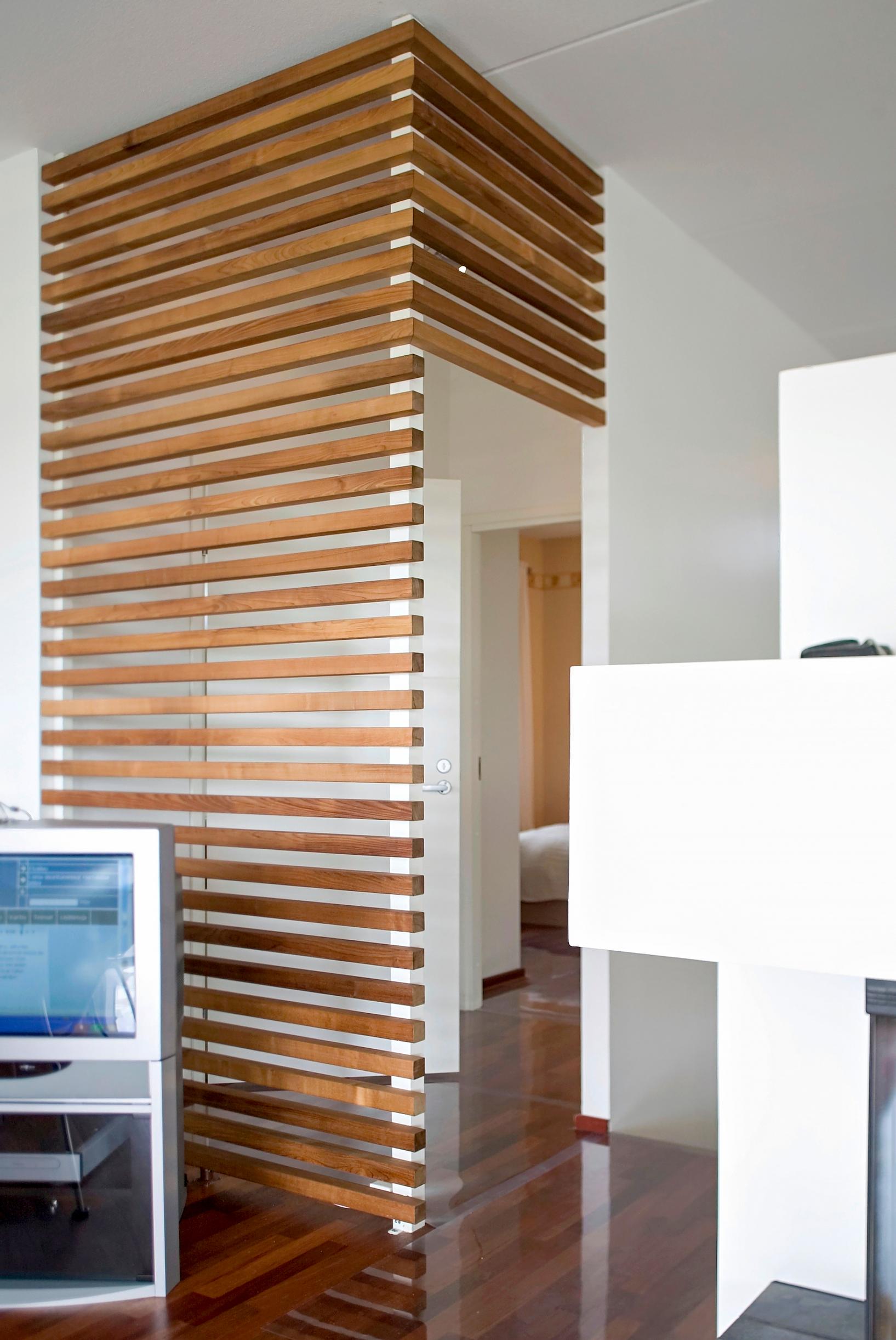 A slatted element guiding movement through a doorway