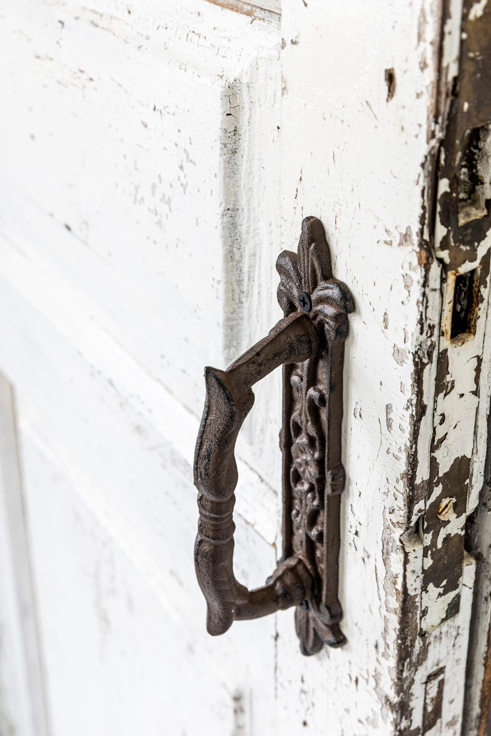 An old door handle and a weathered door