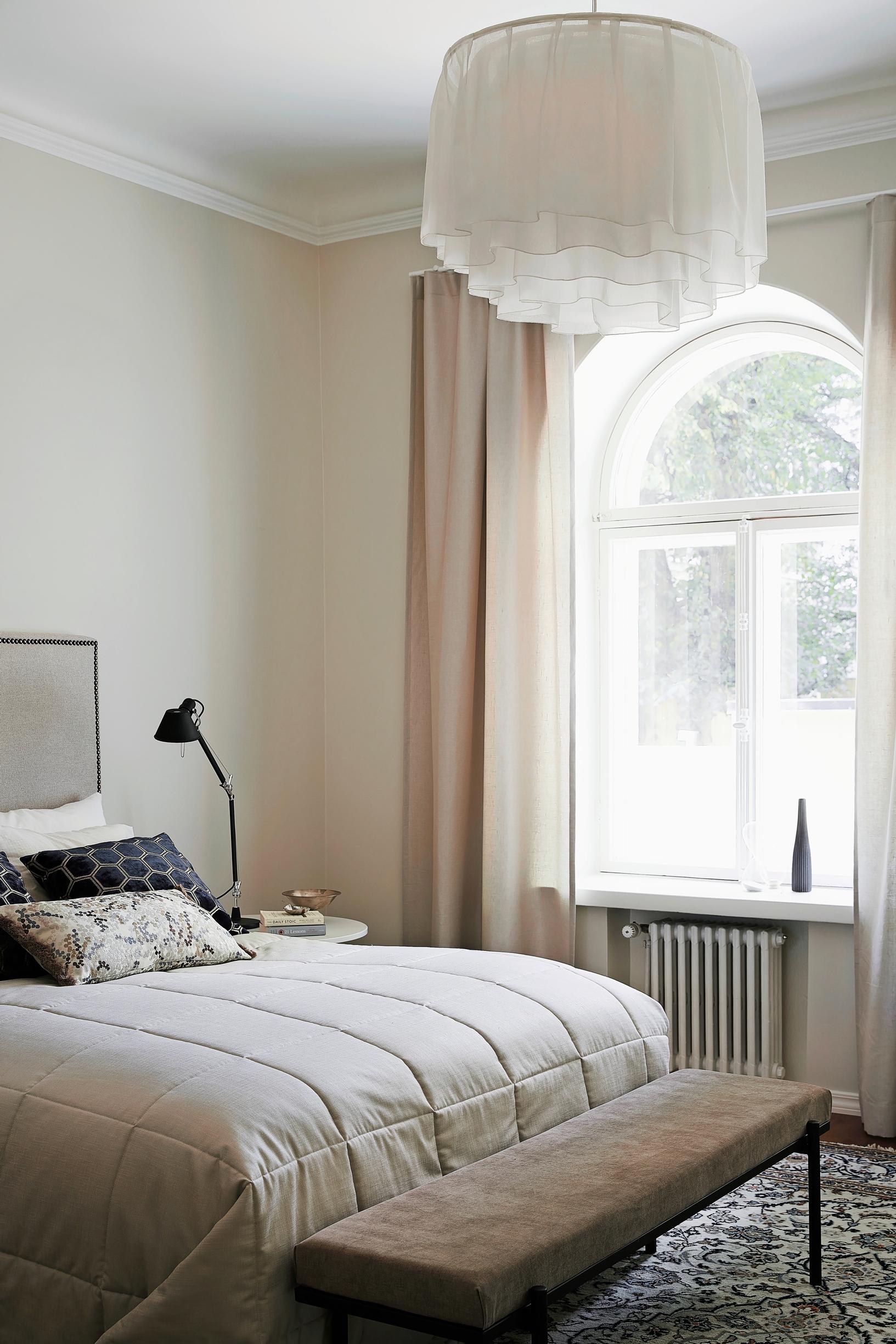 In the bedroom, the curtains match the wall color, and there are plenty of textiles