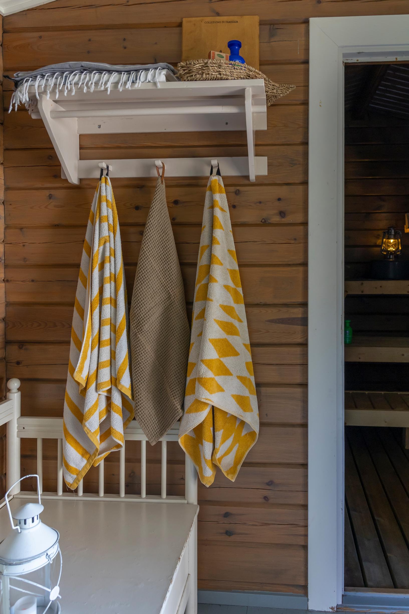 towels on a rack, a lantern, and a wooden sofa