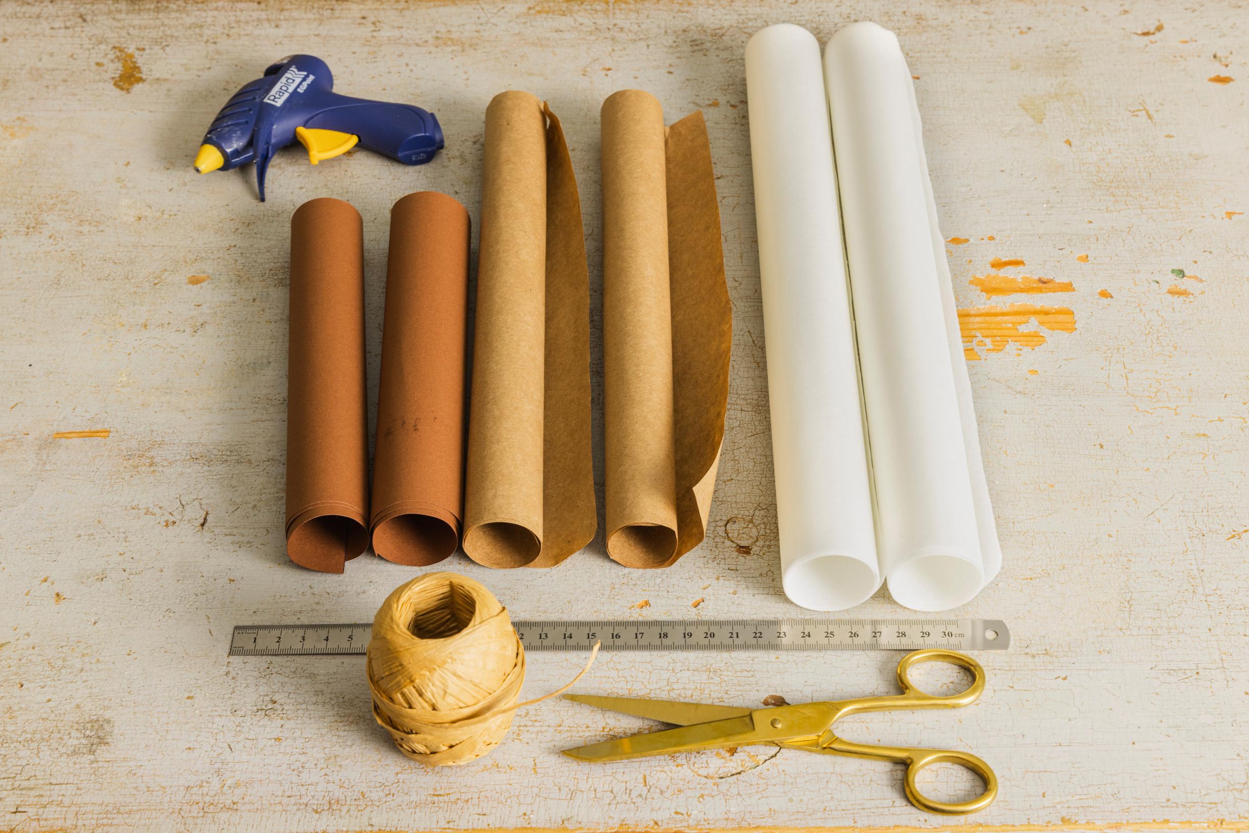 Materials for making a layered star: papers in various sizes, scissors, ruler, hot glue gun, and string.