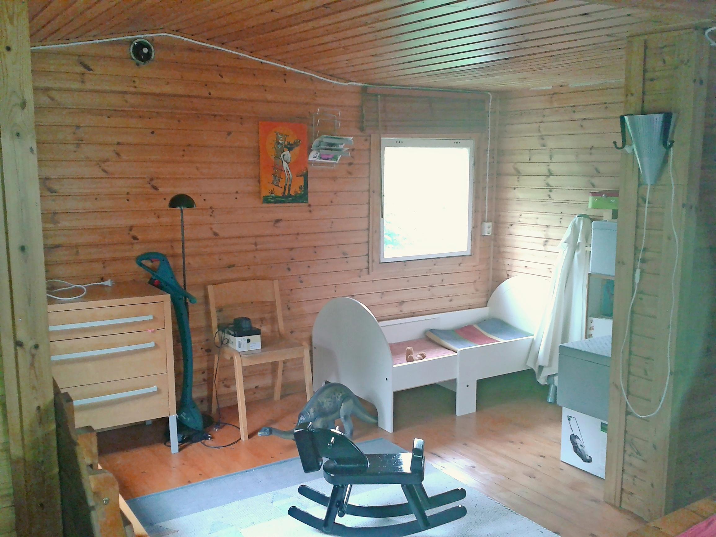 a rocking horse and old furniture in a cottage with unrenovated pine walls