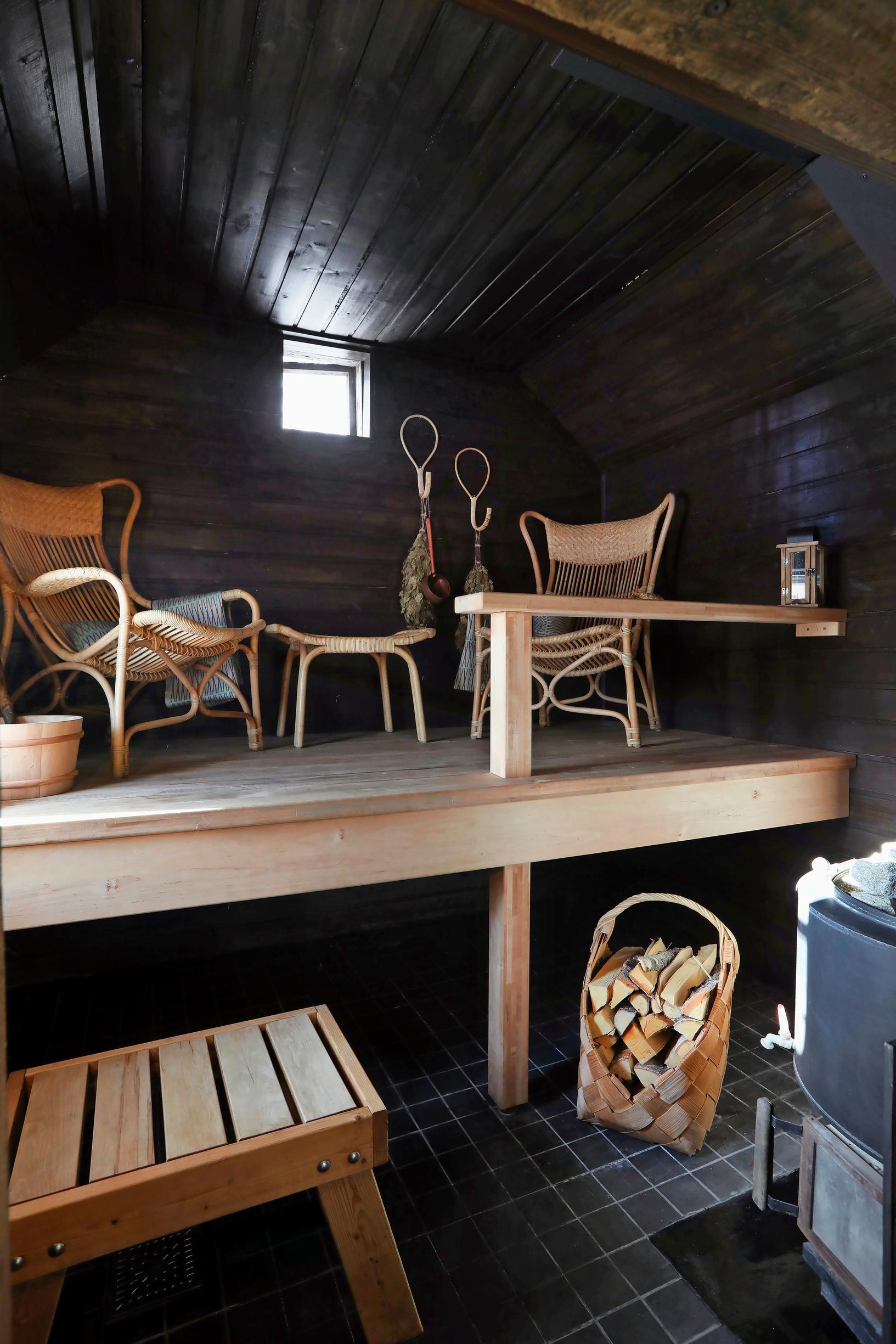 Rattan chairs and ottoman on the benches, stove and firewood carrier