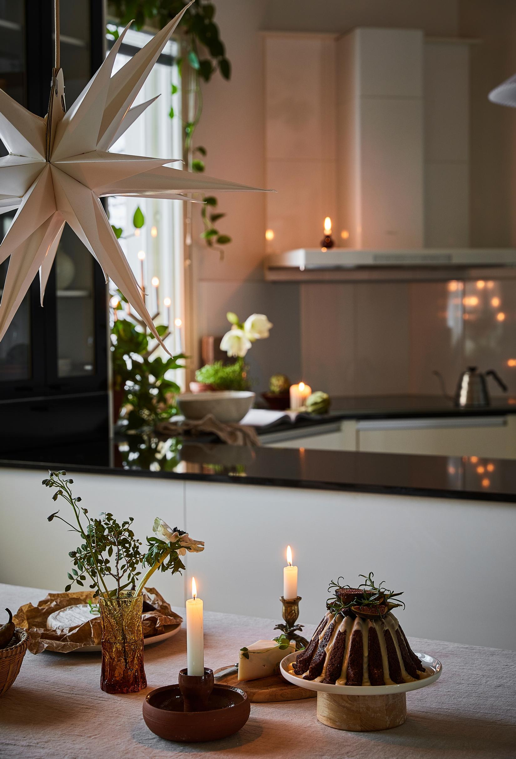 A festively decorated kitchen with candles, a cake, and a Christmas star
