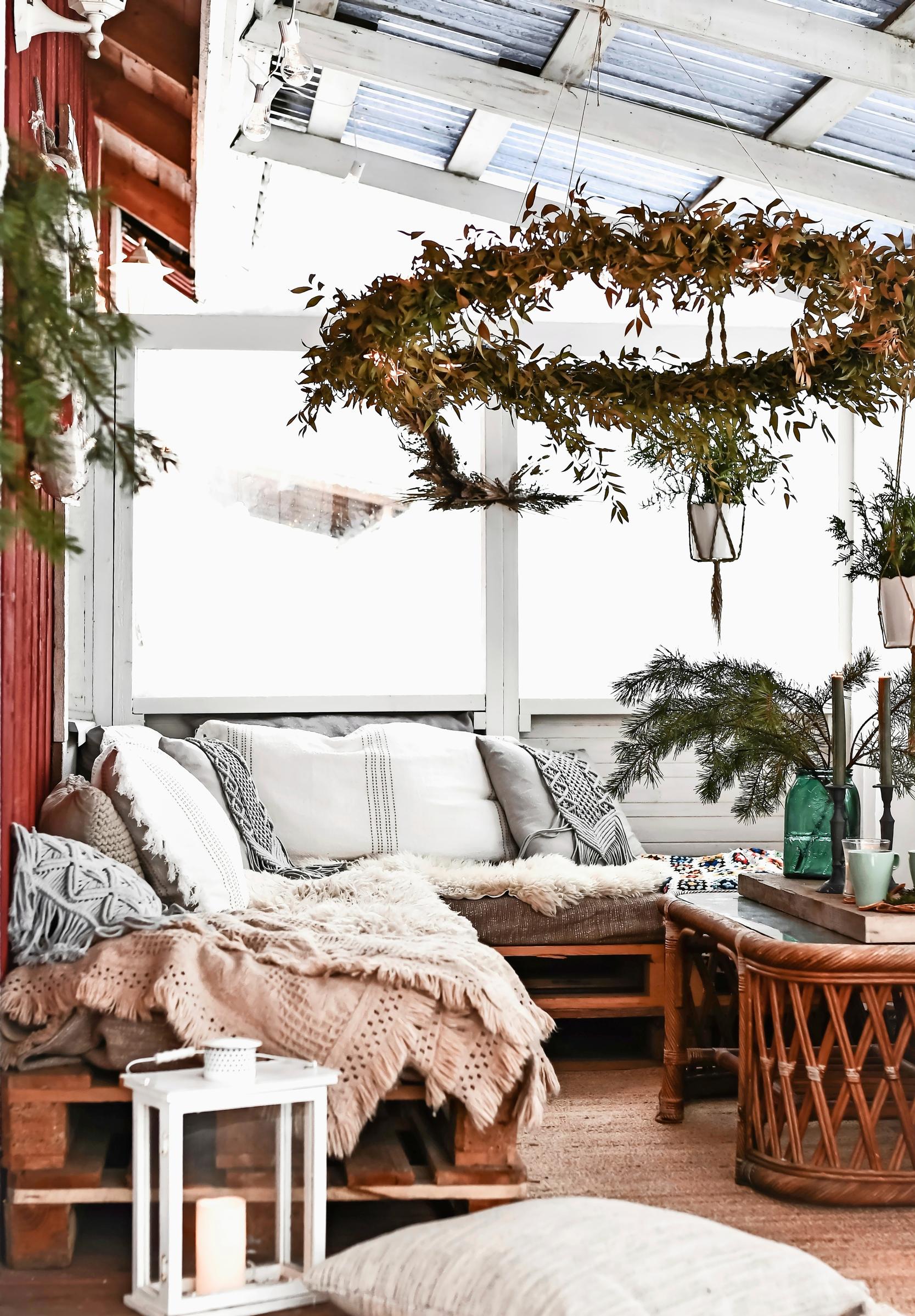 Light-colored textiles on a corner sofa made from pallets.
