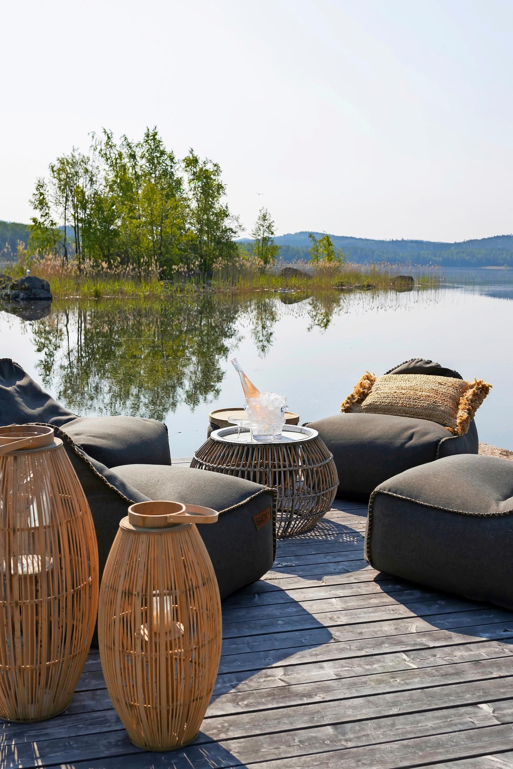 On the dock, a summer living room with tables, lanterns, and comfy beanbag chairs
