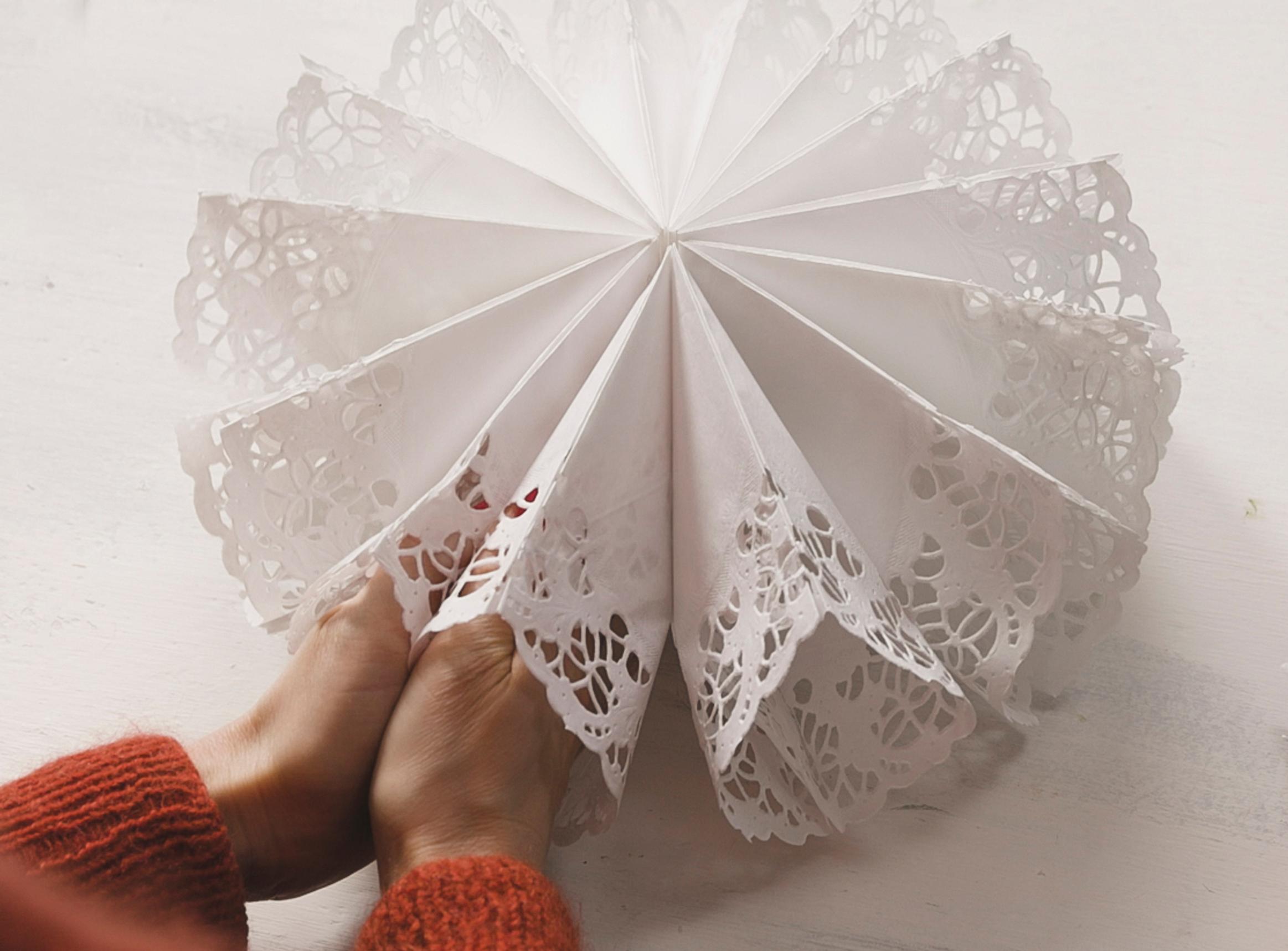 Opening the paper doily star into a circle and gluing it