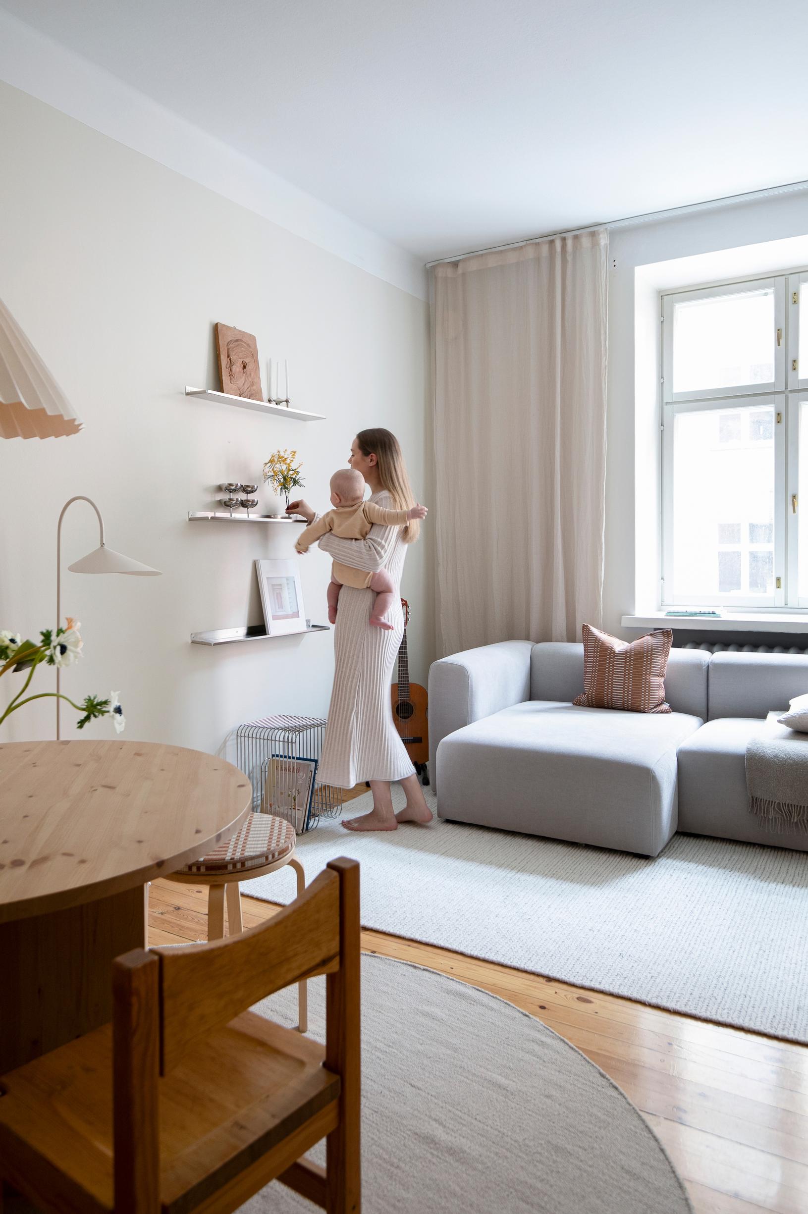 In the living room, metal shelves and easy-care upholstery