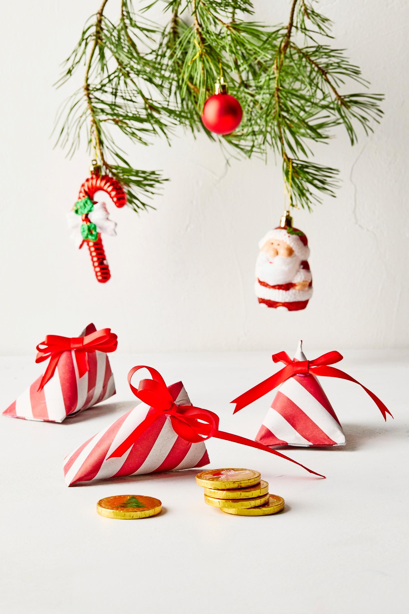 Triangle packages crafted from toilet paper rolls, covered with striped gift wrap.