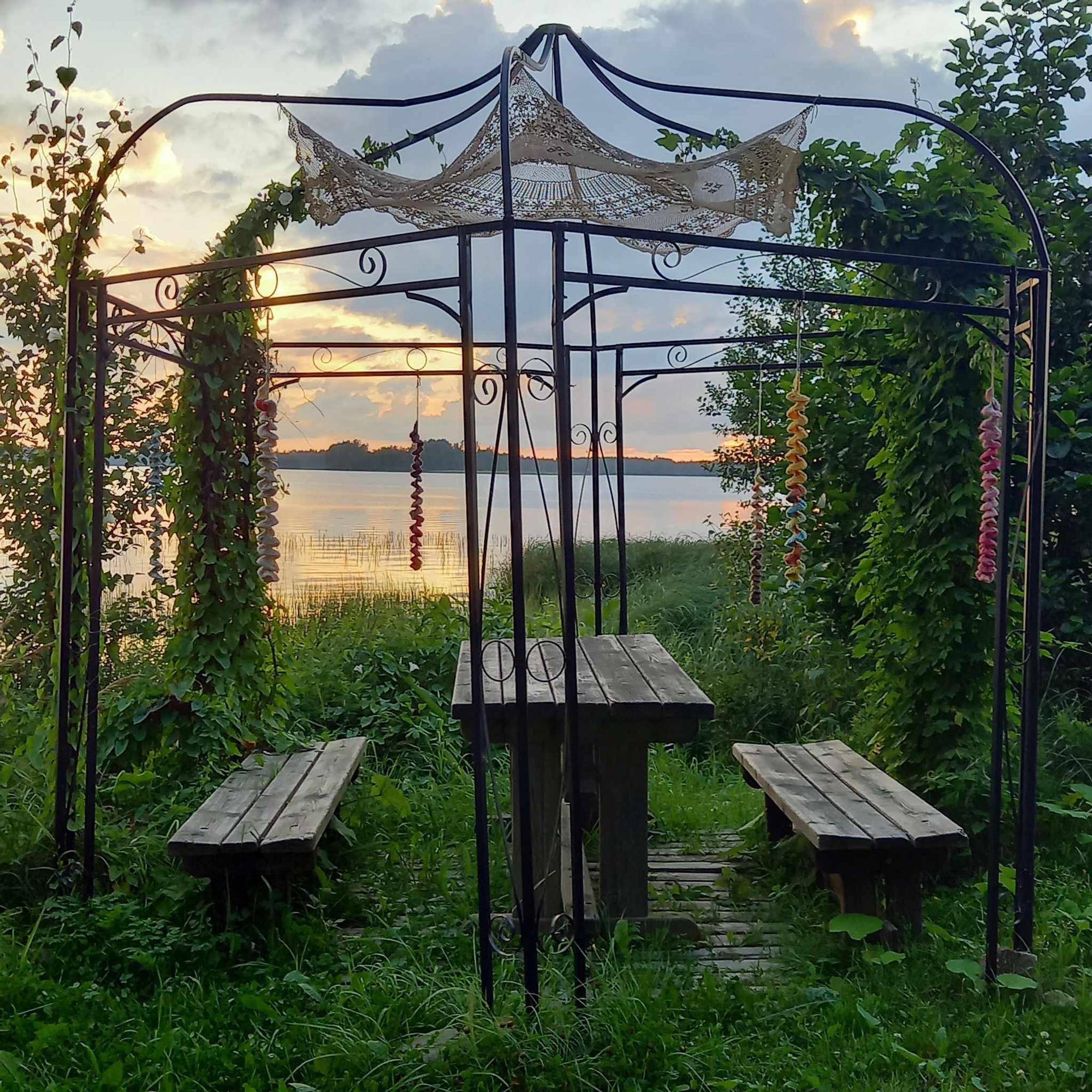 A lace tablecloth on the ceiling of a garden pavilion.