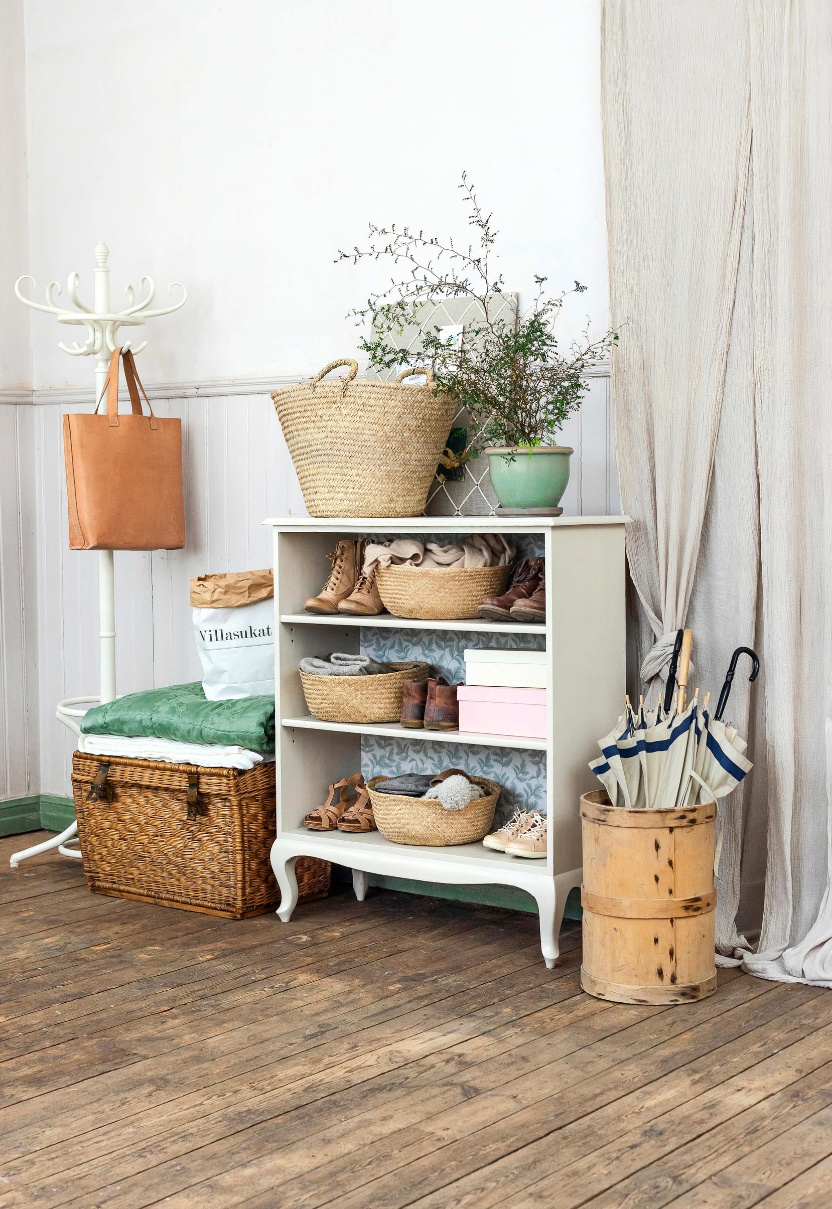 A shoe shelf upcycled with linseed oil paint and wallpaper in a hallway.