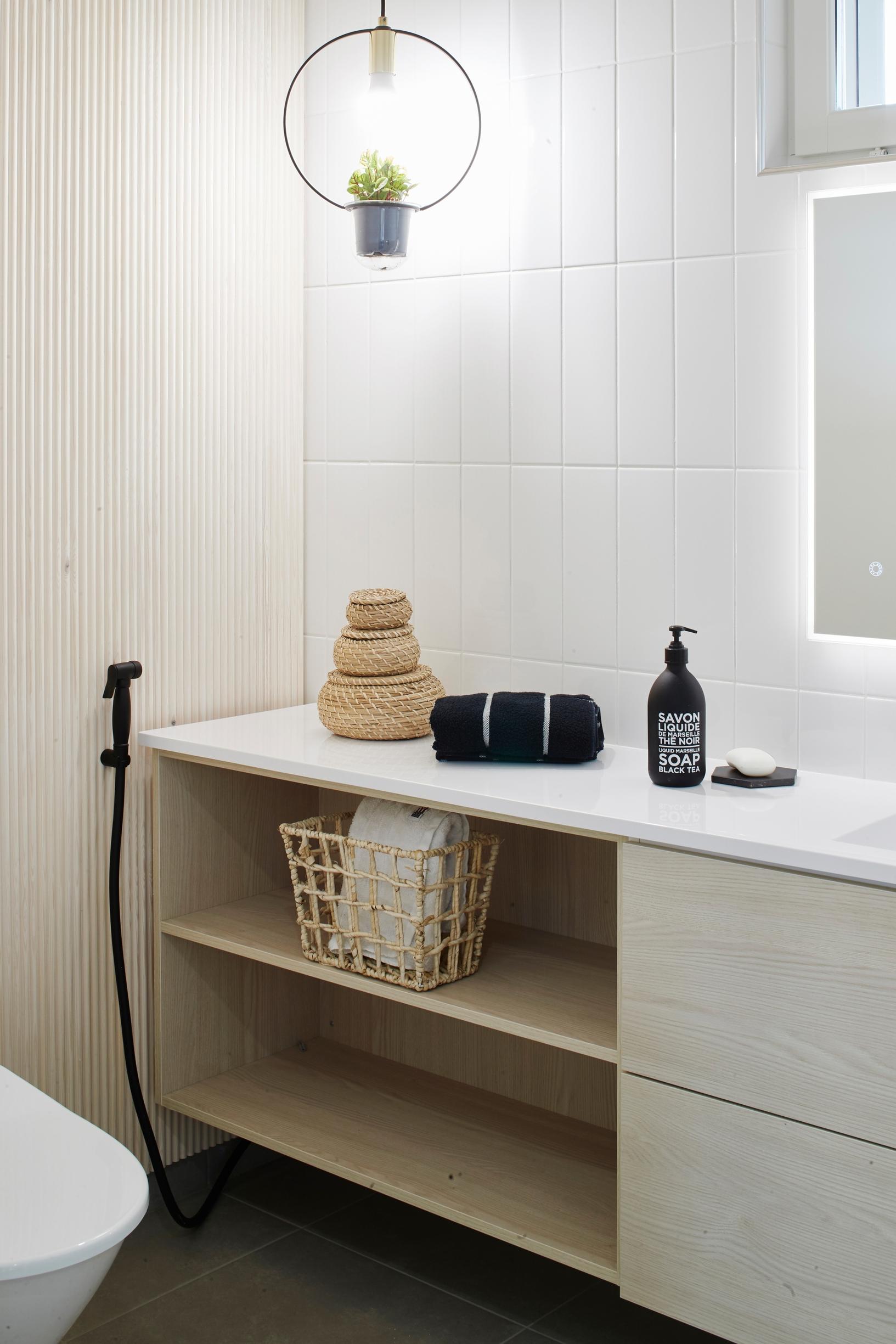 Narrow bathroom featuring slatted paneling and vertical tiles