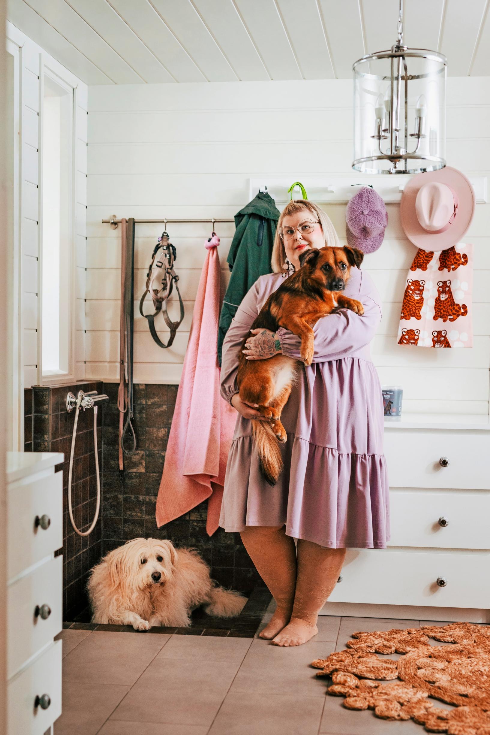 A woman stands in the entryway with her two dogs.