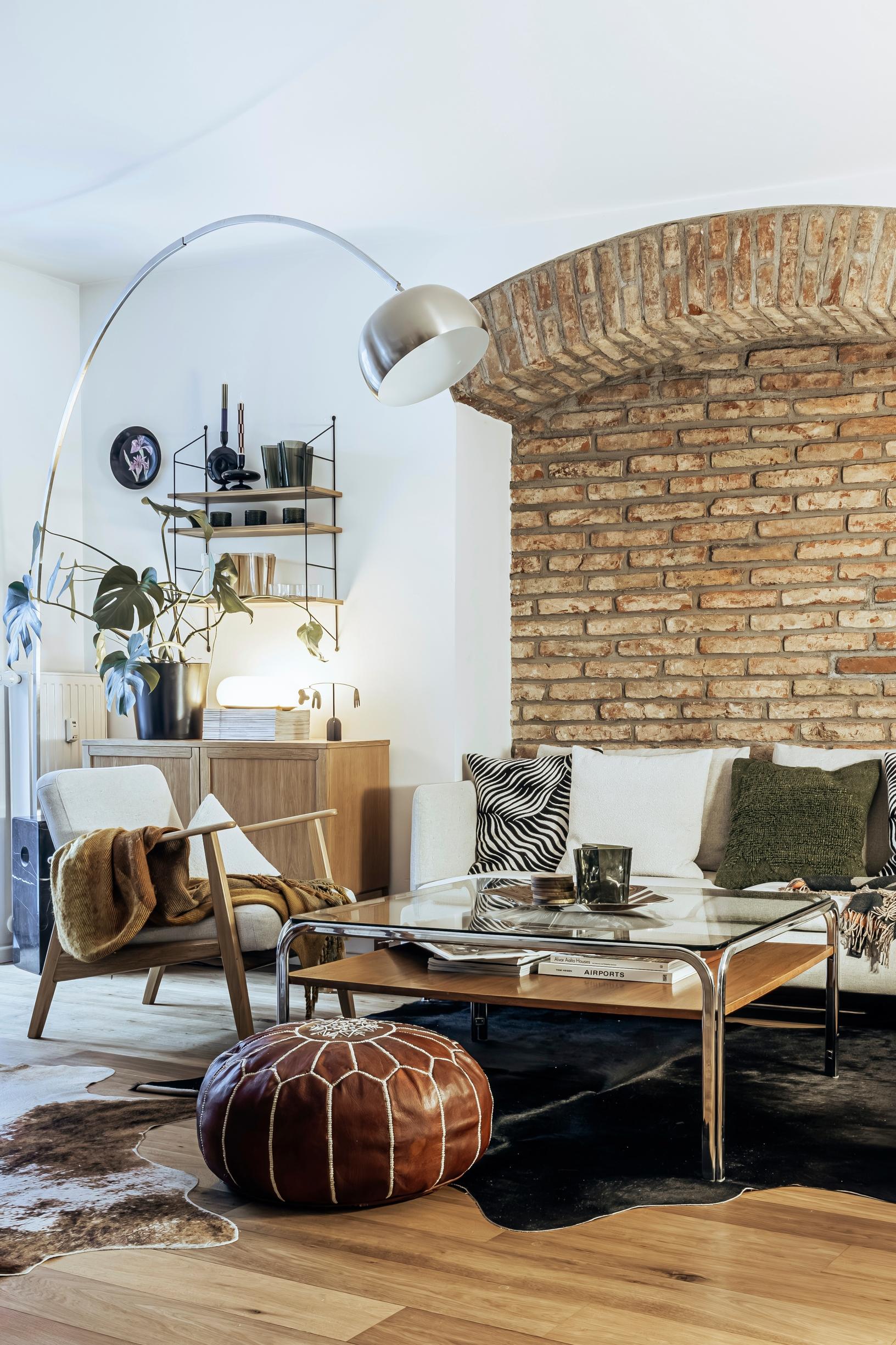 A curved brick wall behind the couch.