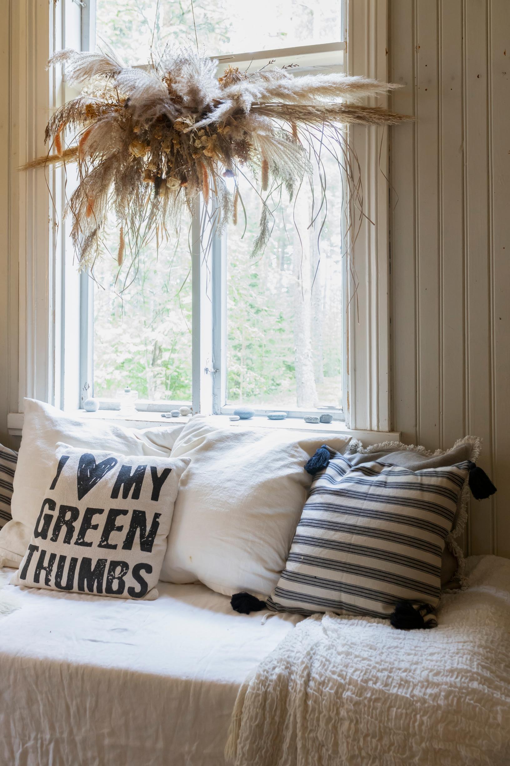 Sofa cushions on a sofa in front of a window.