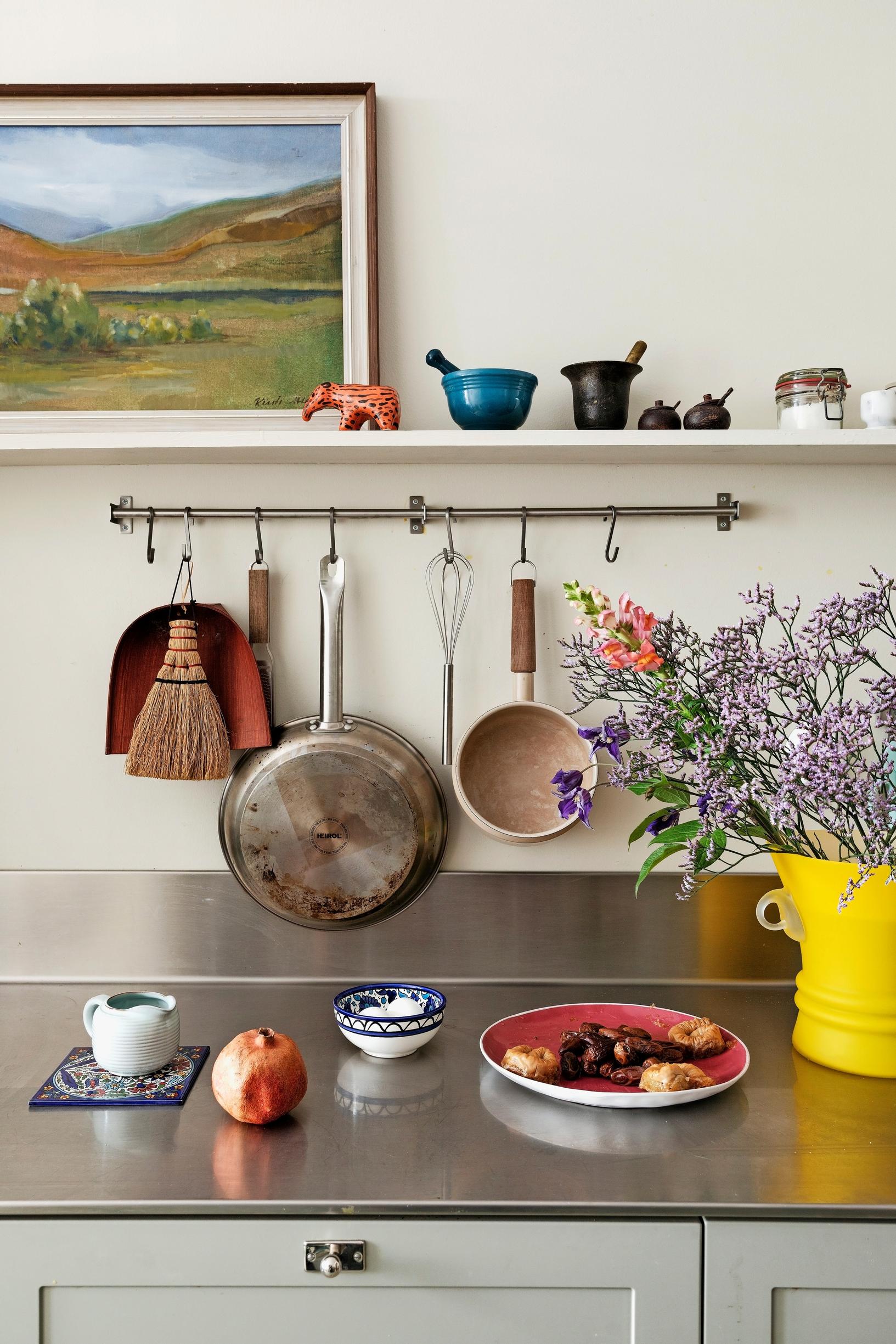 Image of a kitchen with artwork and a stainless steel countertop.