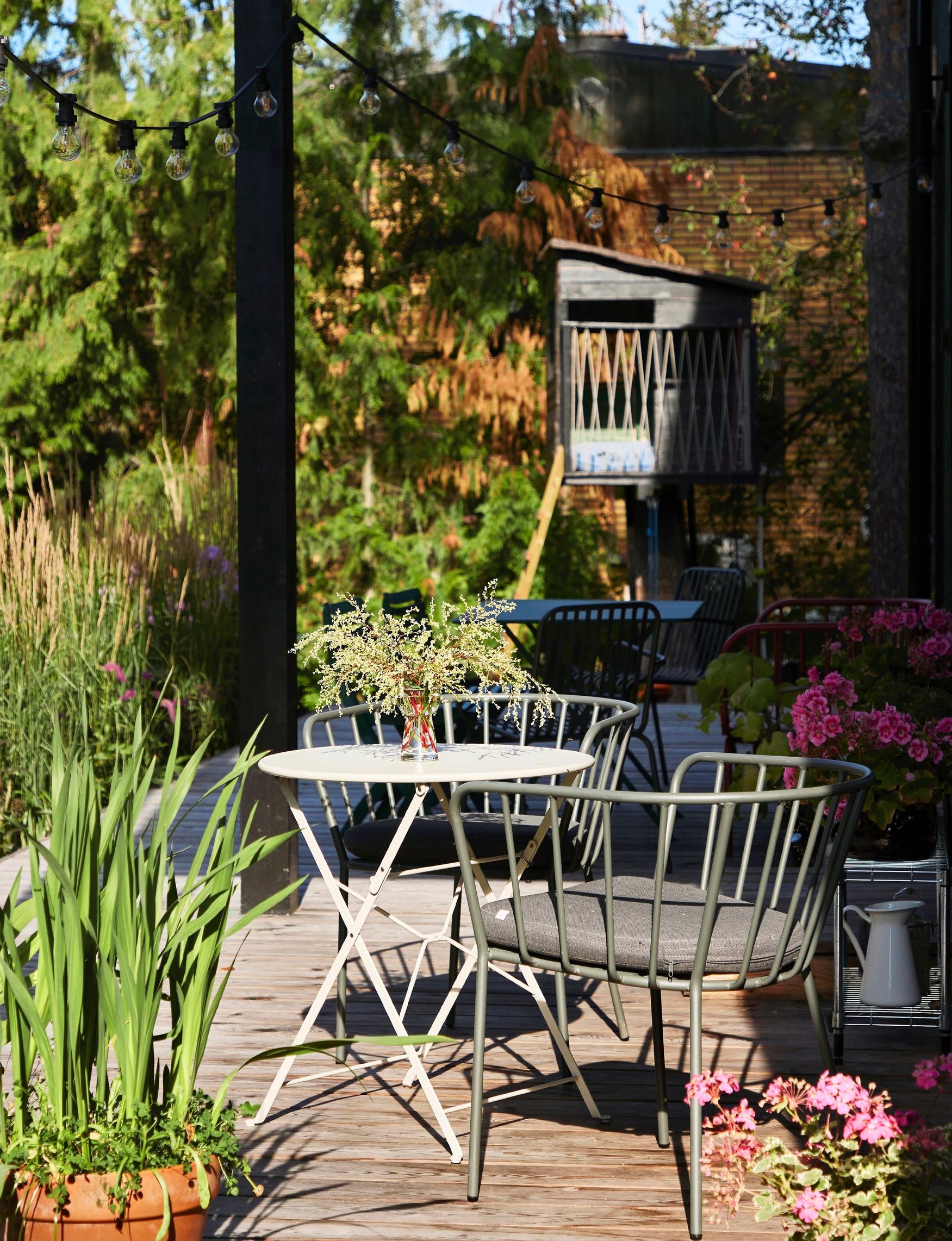 A single-family home’s terrace featuring Japanese-inspired flower beds and metal furniture