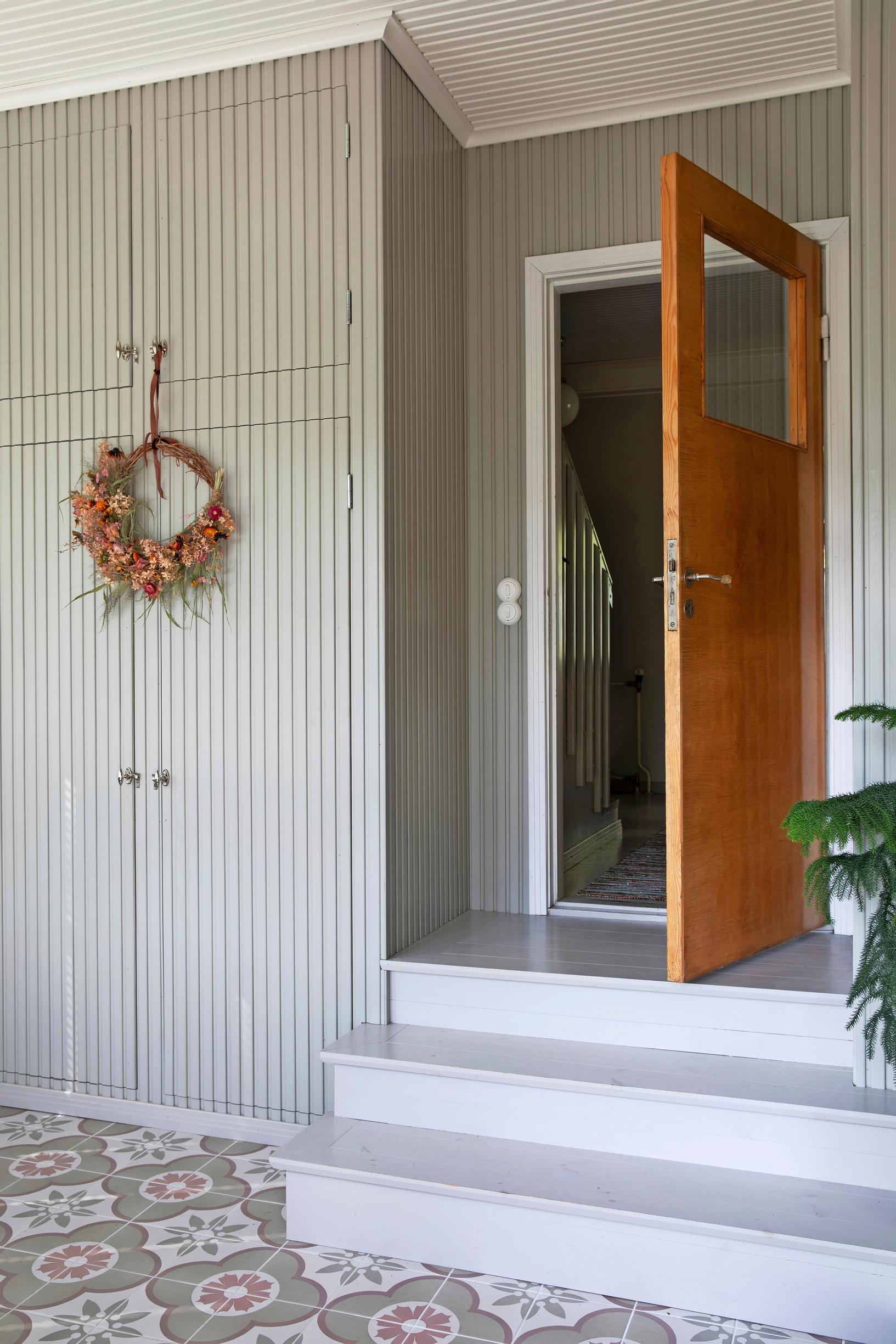 The space has a decorative tile floor and stairs. The cabinets are on the left side of the stairs.