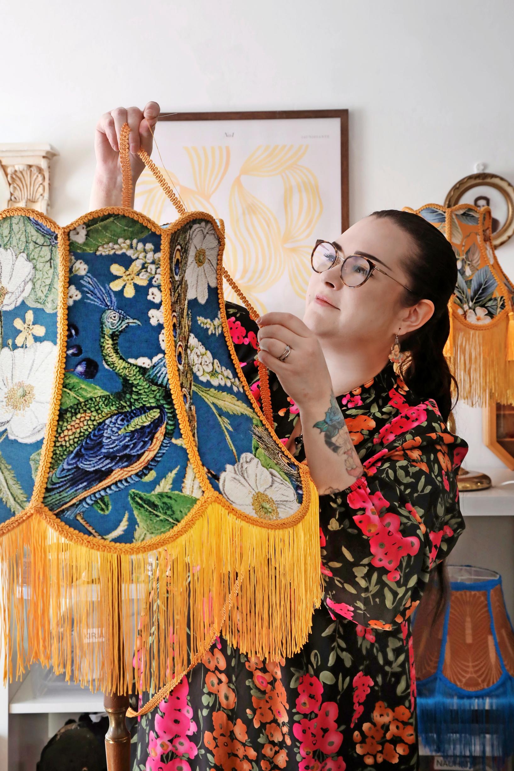 Janni attaching decorative trim to a lamp.