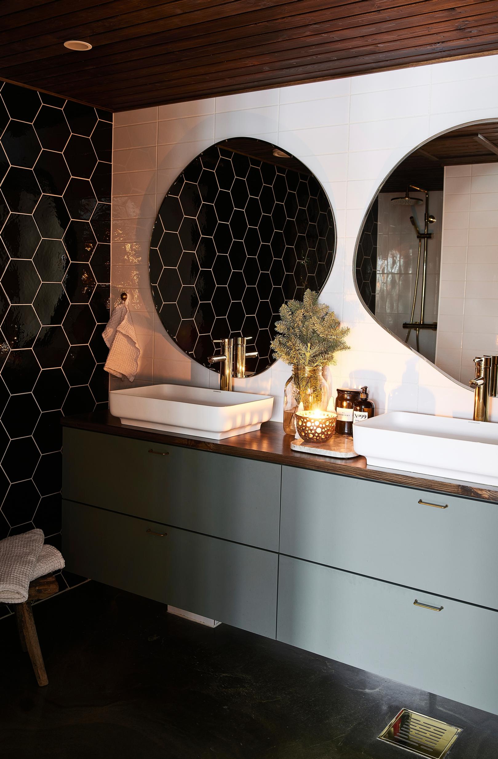 A green vanity and hexagonal tiles in the bathroom.