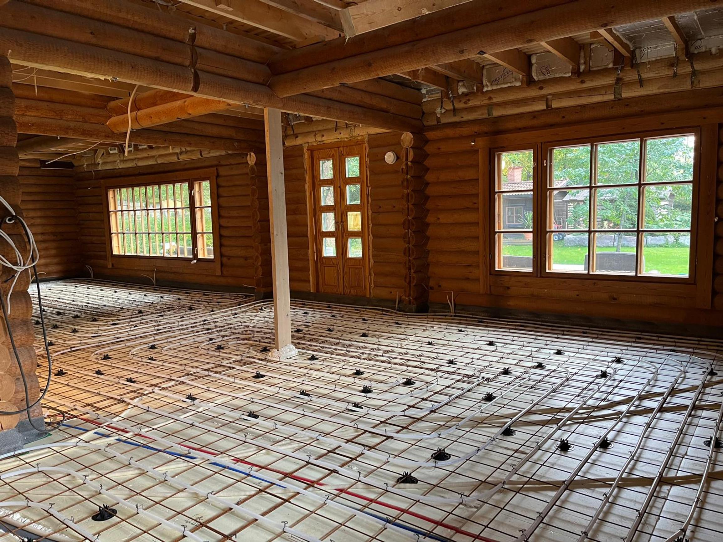 The log house floor is opened up. You can see the underfloor heating pipes.