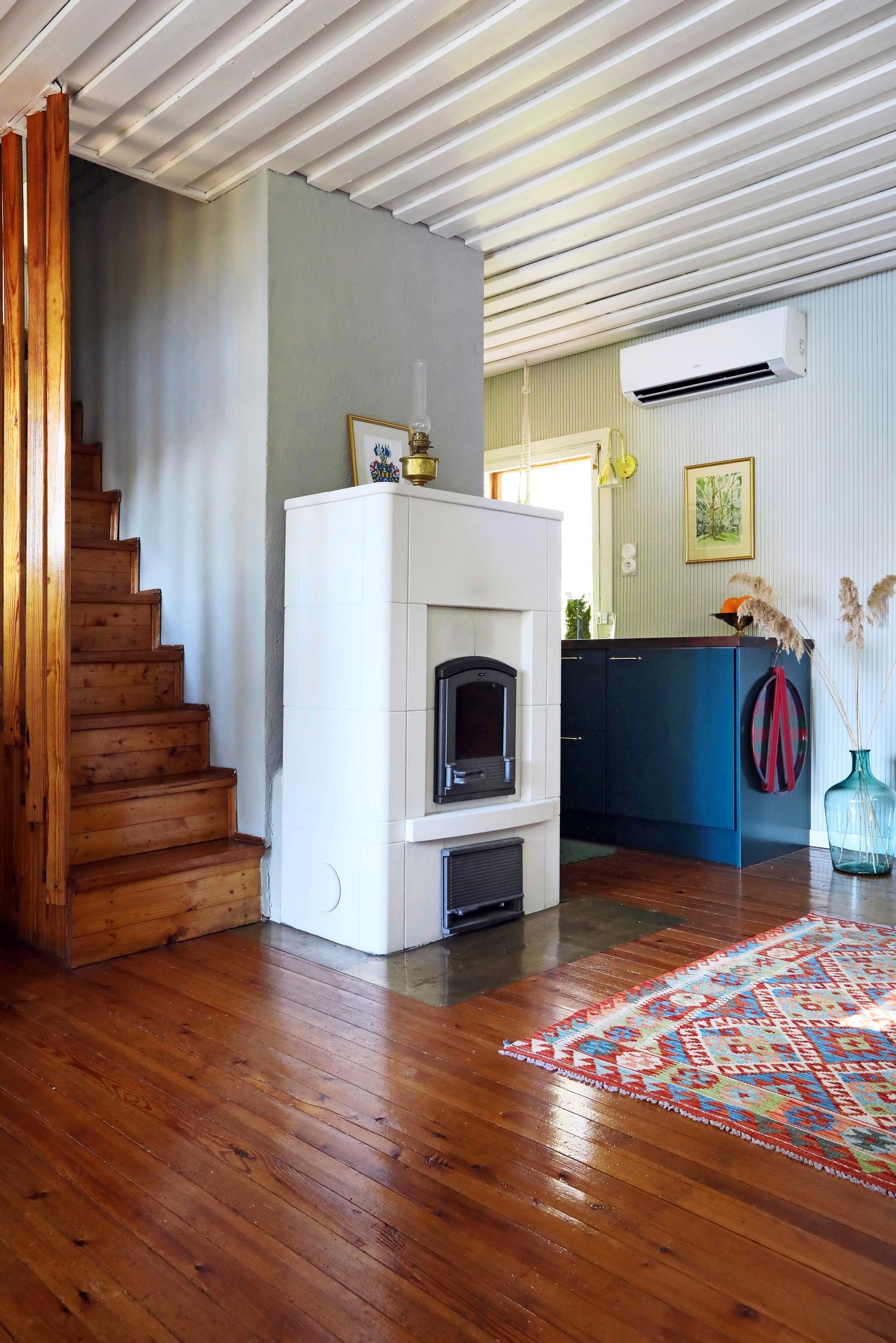A white fireplace and a reddish-brown floor