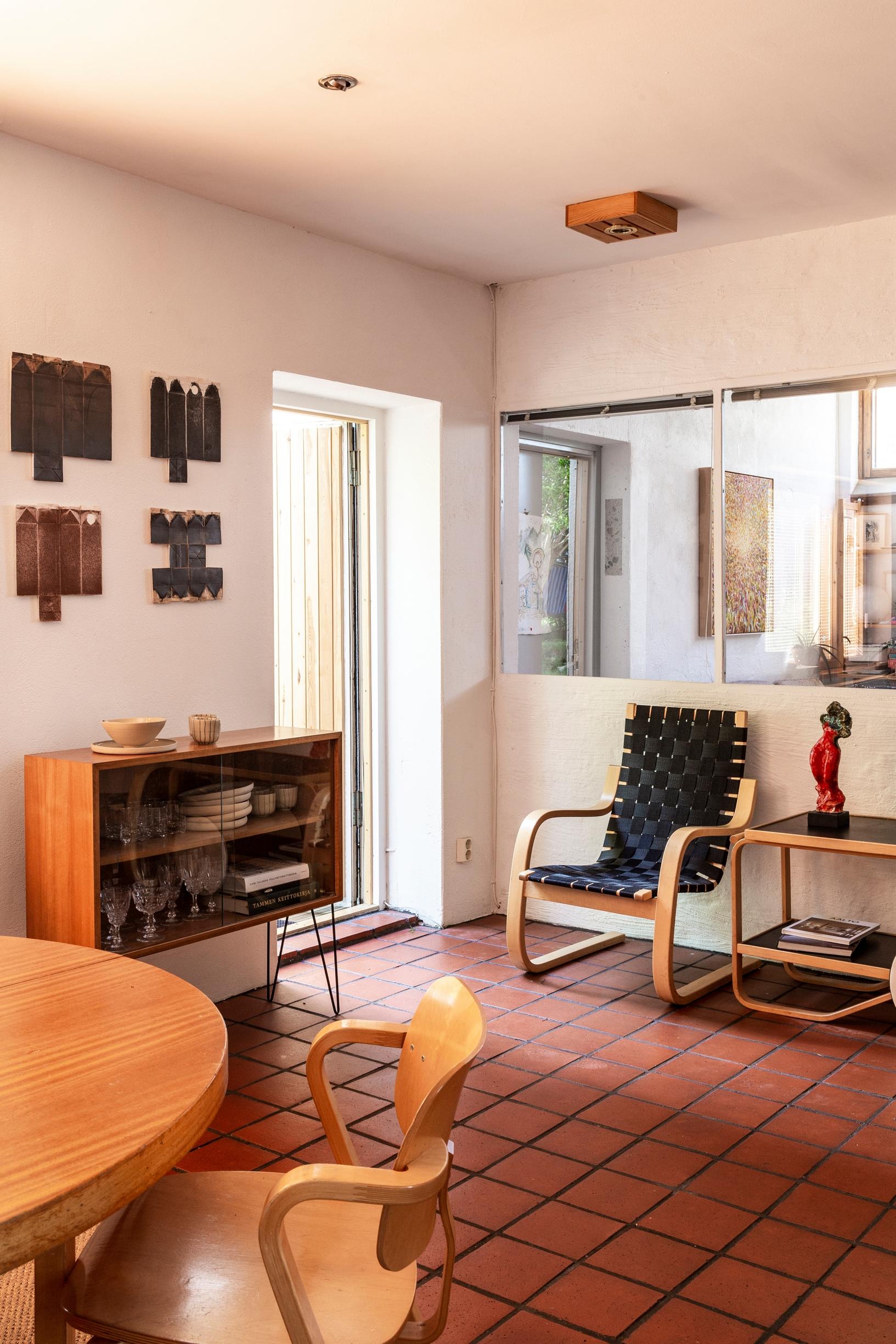 Dining area in the Alvar Aalto–designed heating plant home, Artek furniture, tiled floor, and a sideboard