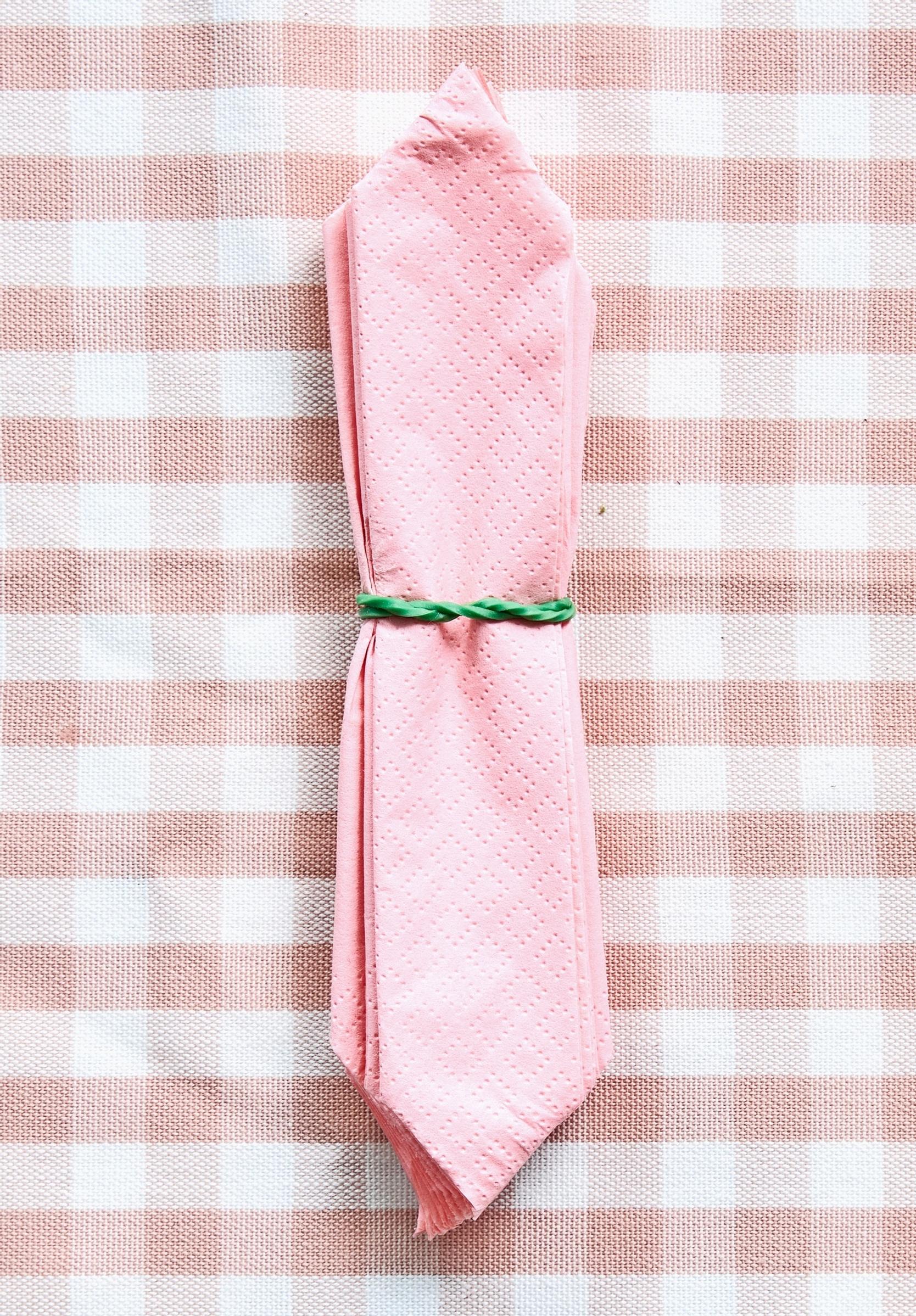 Both ends of the accordion-folded napkin are cut to a pointed tip.