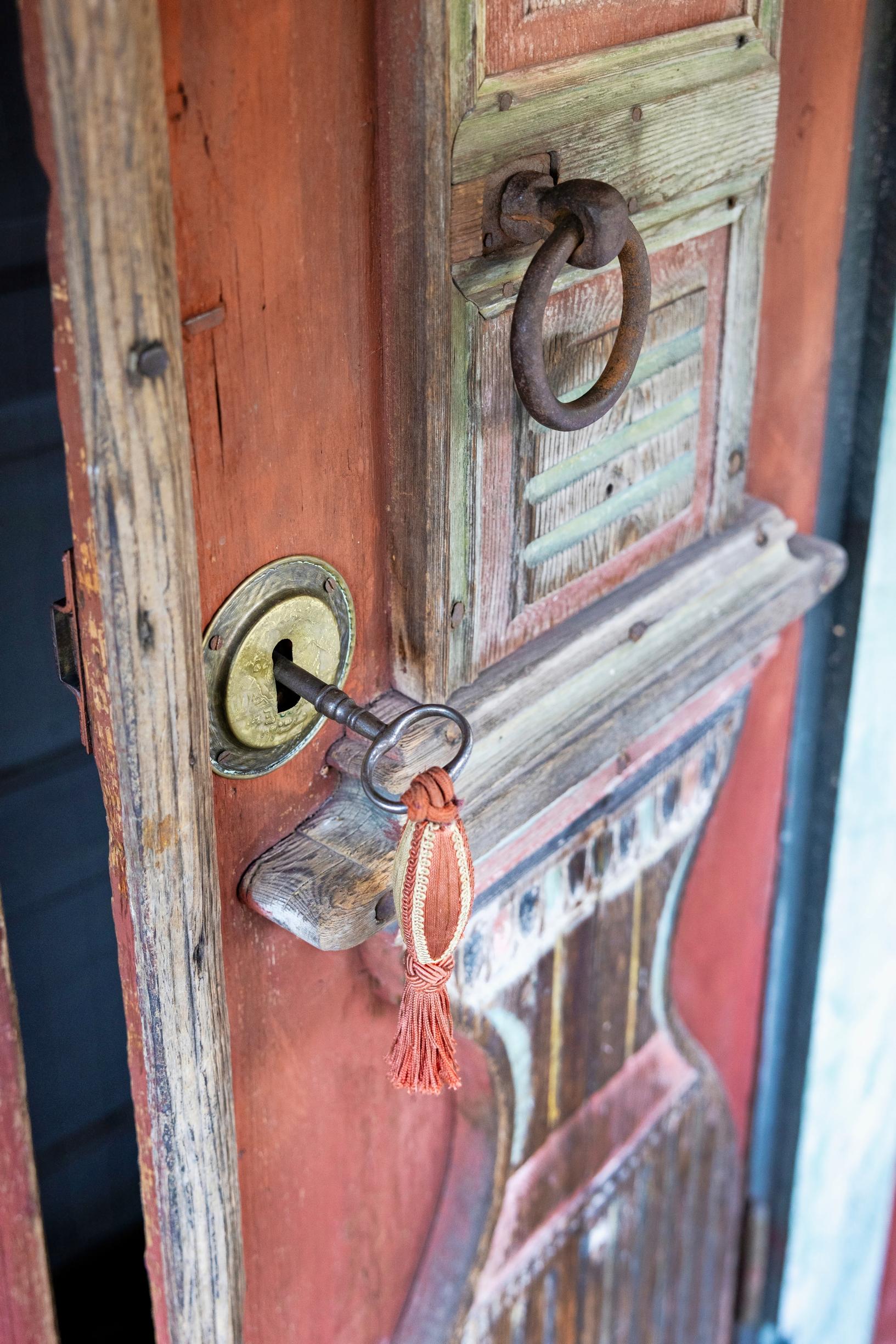 An old door with a key in the lock.